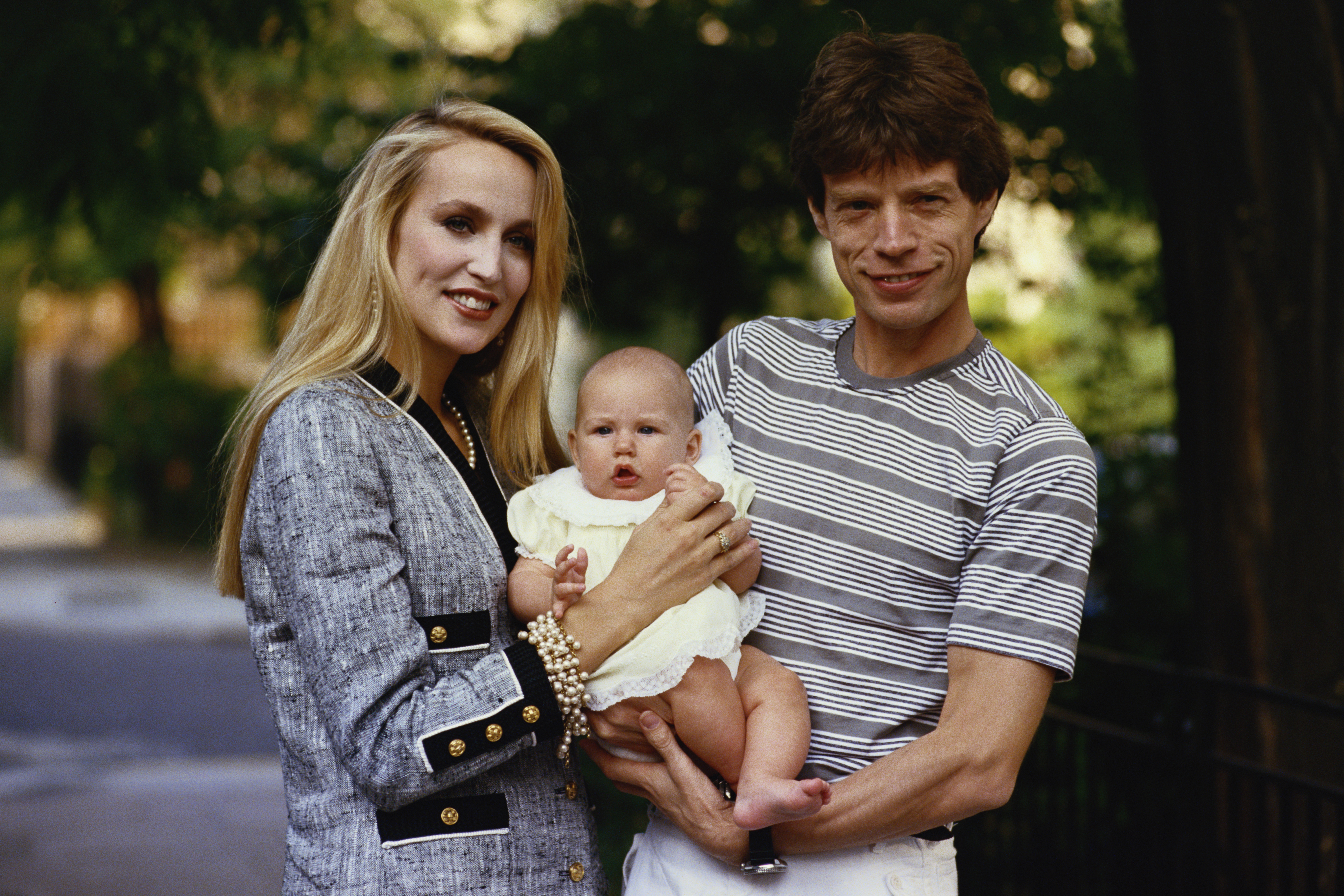 Mick Jagger and Jerry Hall with one of their children, circa 1990 | Source: Getty Images
