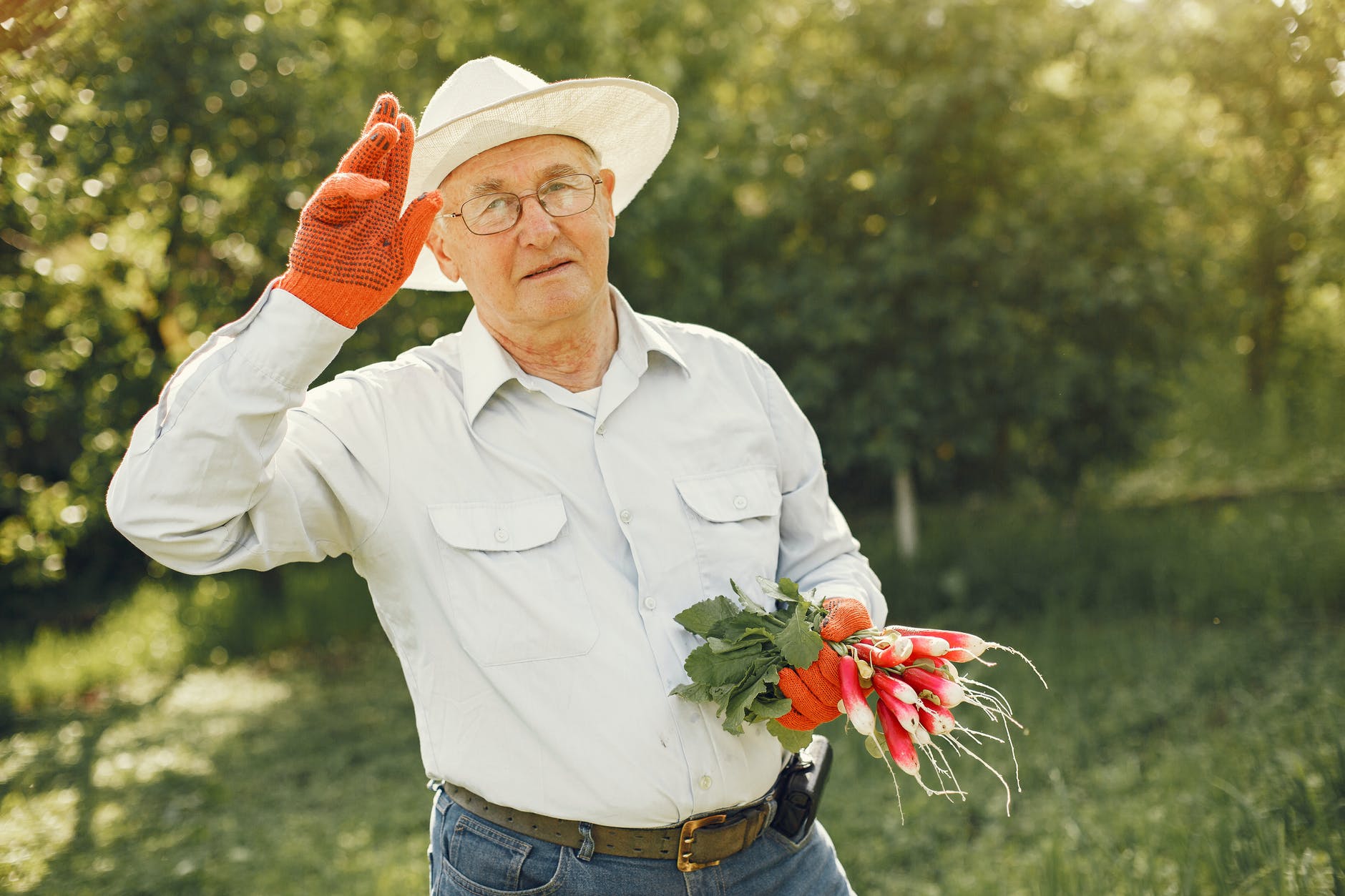 Man in gardening clothes with a handful of radishes | Source: Pexels