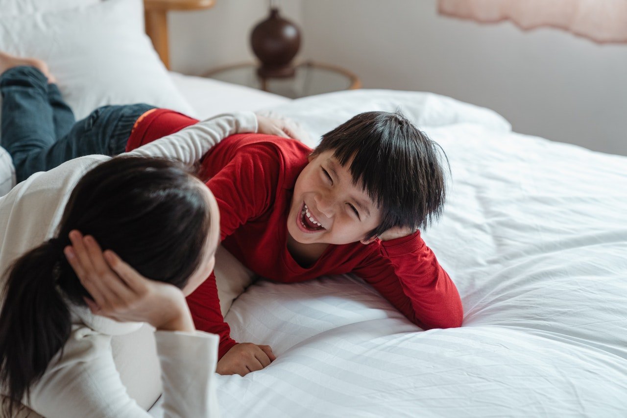 Young boy and mother smiling together | Photo: Pexels