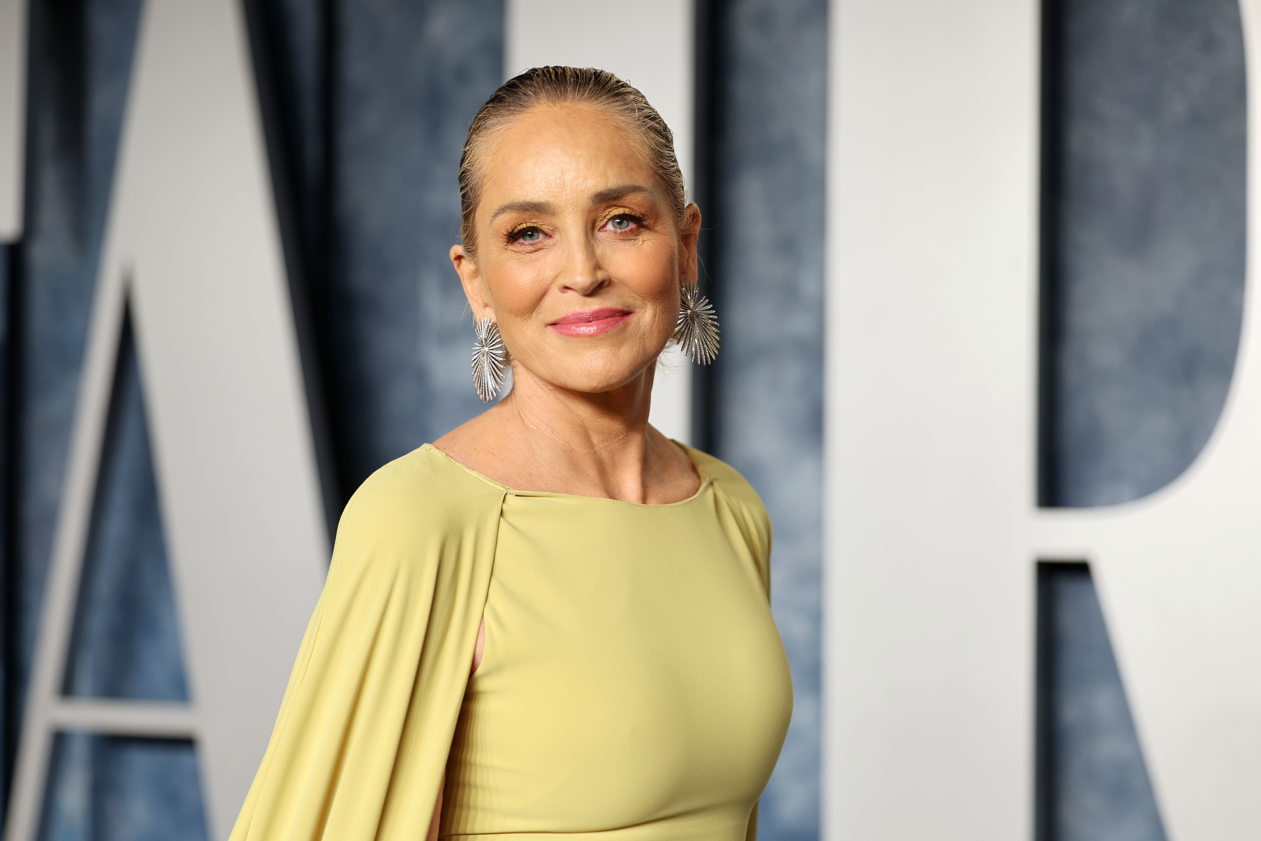 Sharon Stone turns heads at the Vanity Fair Oscar Party in a dazzling blue-and-white gown, bringing classic movie-star glamour to one of Hollywood's most celebrated nights.