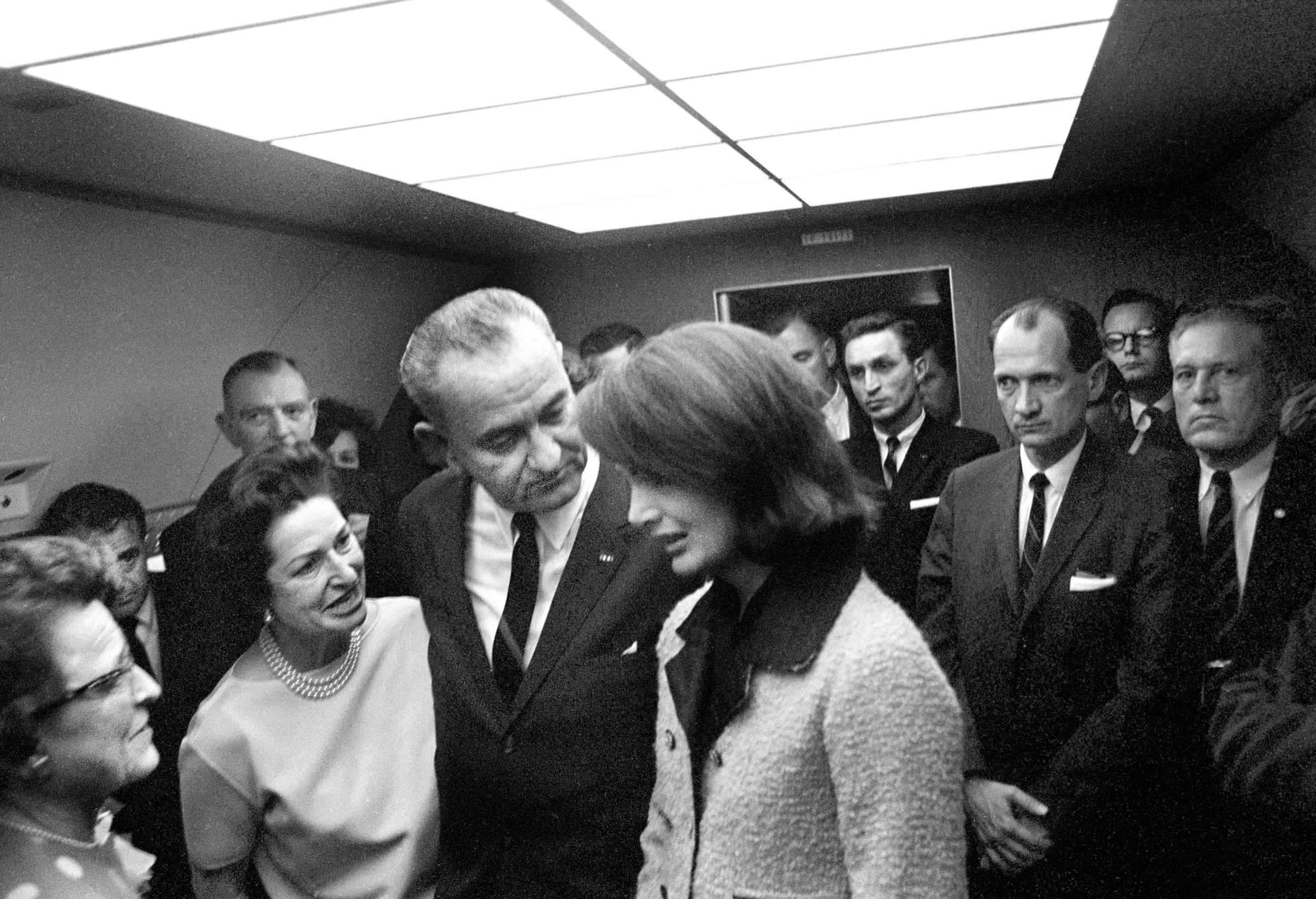 Lyndon Johnson and First Lady Claudia "Lady Bird" Johnson consoling Jacqueline Kennedy after Johnson was sworn in as U.S. President by Judge Sarah Hughes aboard Air Force One after assassination of U.S. President John Kennedy on November 22, 1963. | Source: Getty Images