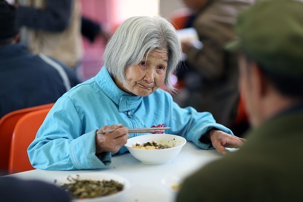 98-year-old lady eating breakfast at a nursing home in Zhenping County | Photo: Getty Images