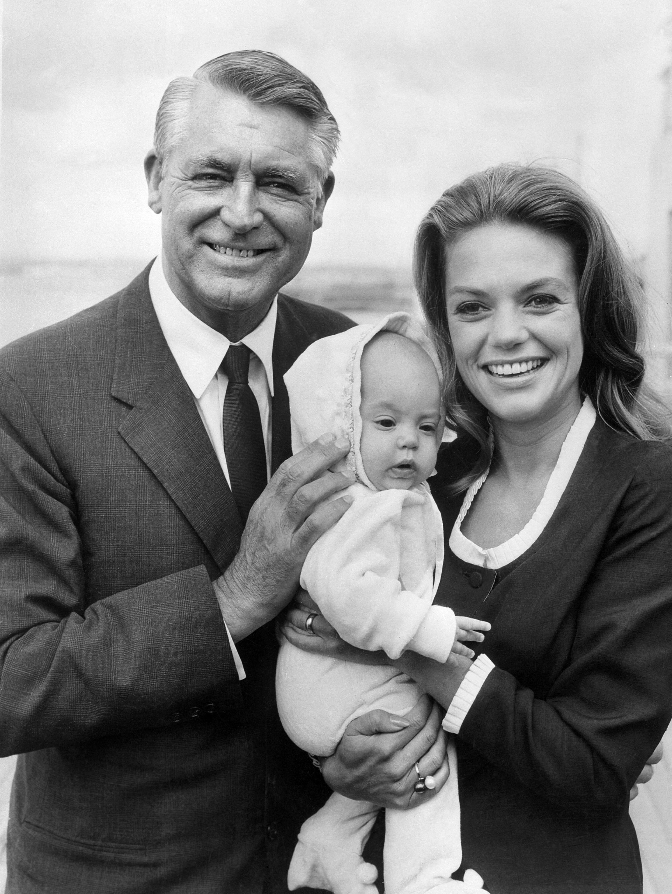 Cary Grant and his wife Dyan Cannon smile as they hold their daughter Jennifer in July 1966 in Los Angeles. | Source: Getty Images
