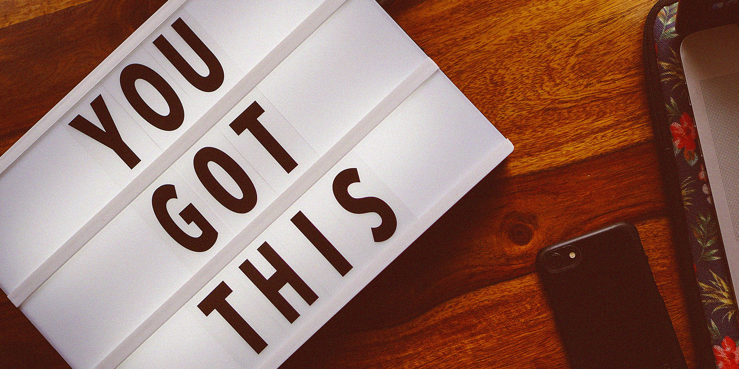 Unsplash | A white board on a table complete with the words "You got this" alongside a phone  and another unidentifiable object