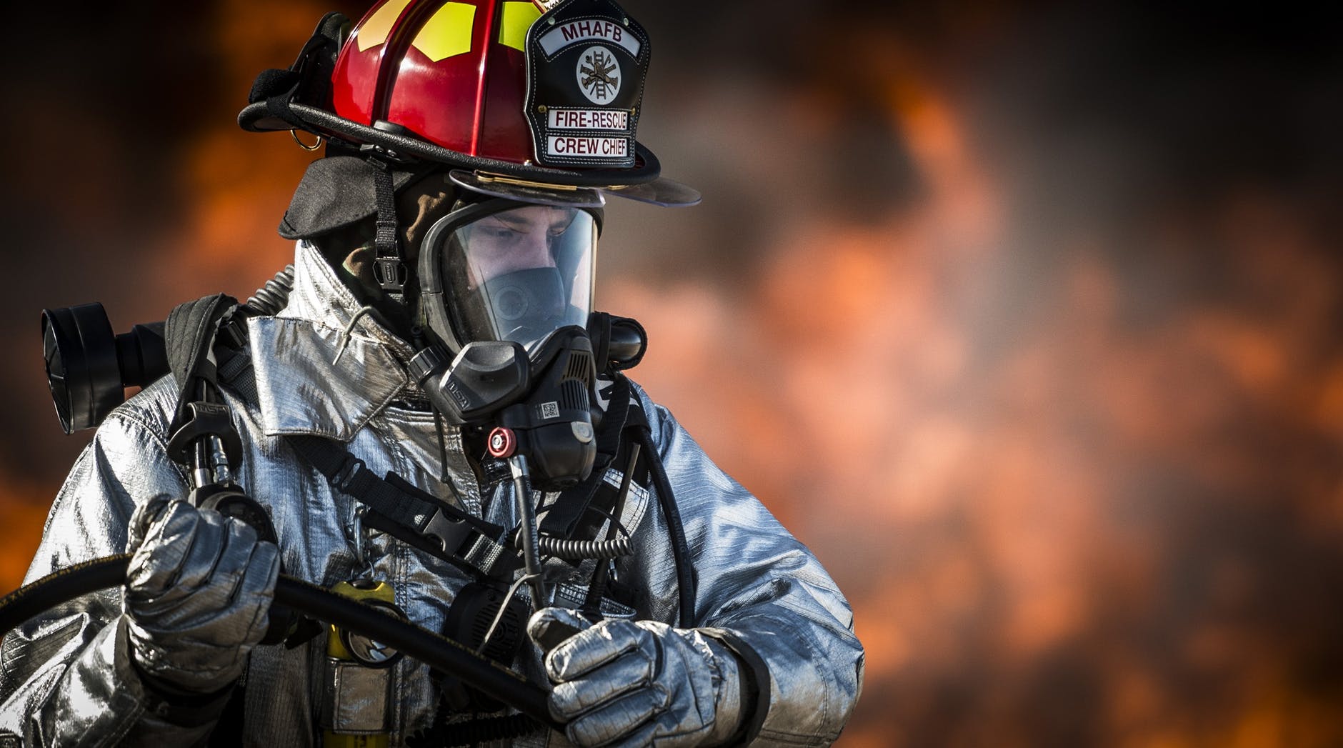 Un bombero con traje protector intentando apagar un incendio. | Foto: Pexels