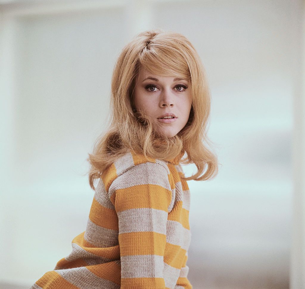A young Jane Fonda posing in a waist-length shot wearing a mustard yellow sweater. | Source: Bettmann/Contributor/Getty Images