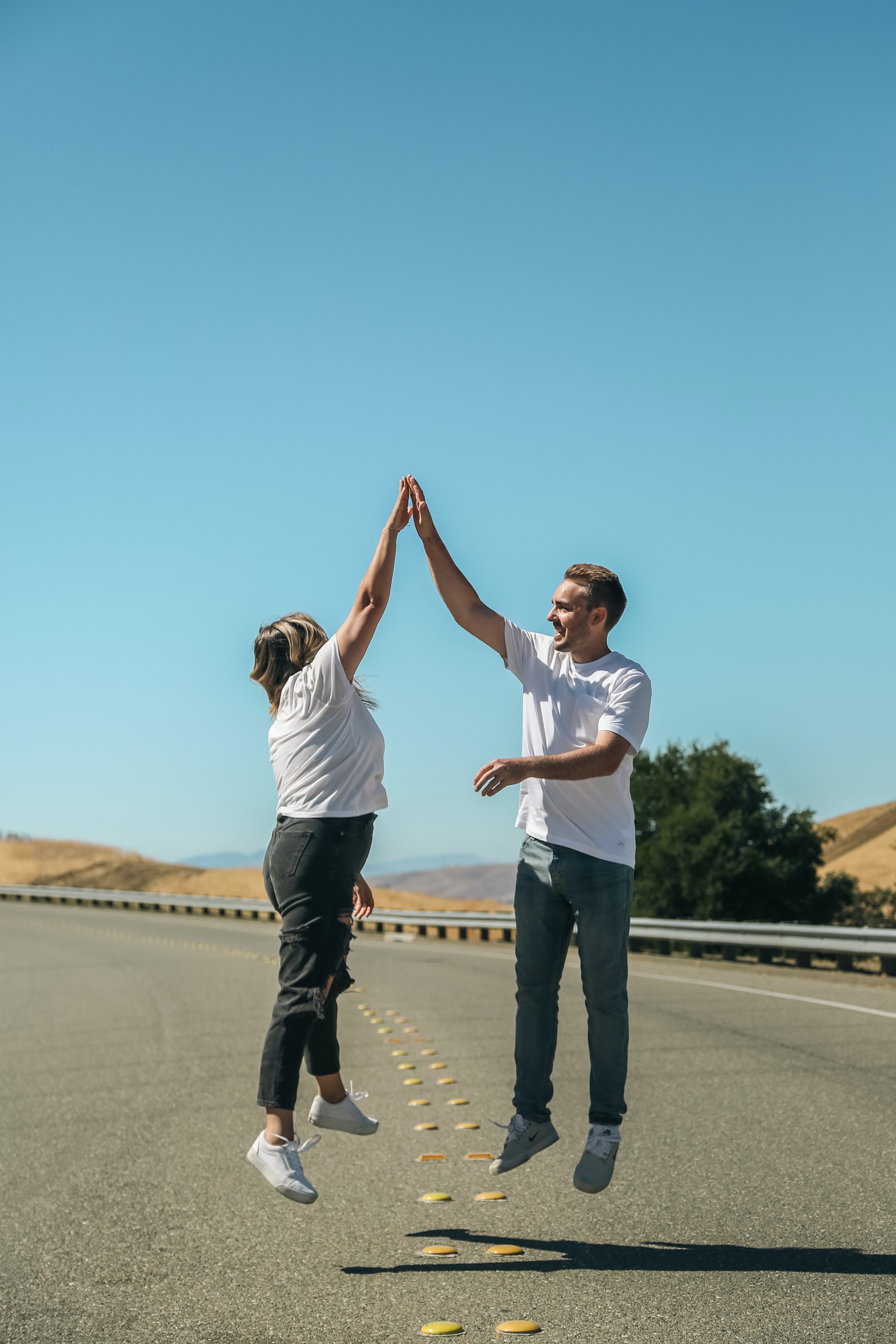 A couple jumping up and high-fiving. | Source: Unsplash