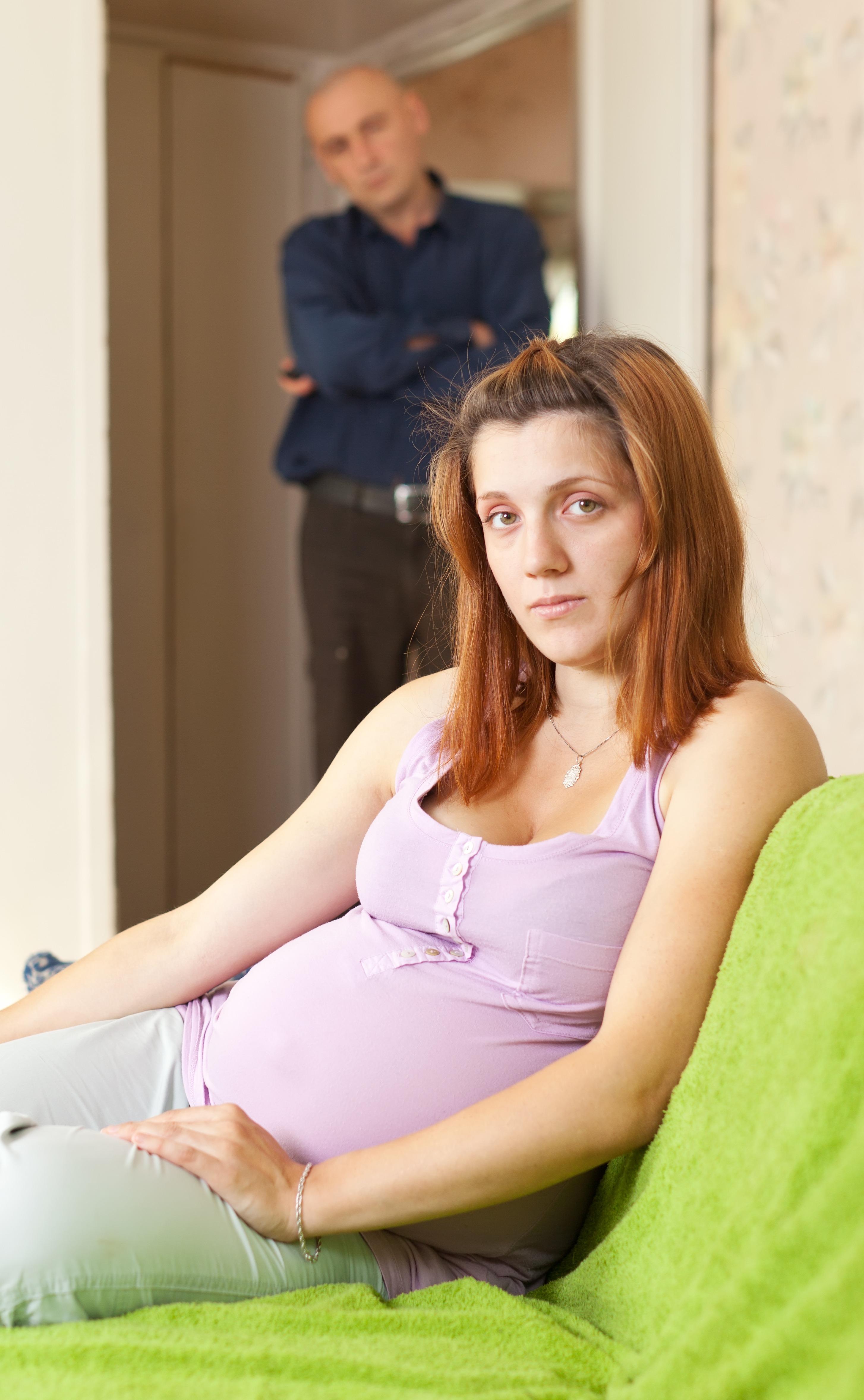 A pregnant woman with a man standing behind her | Source: Shutterstock