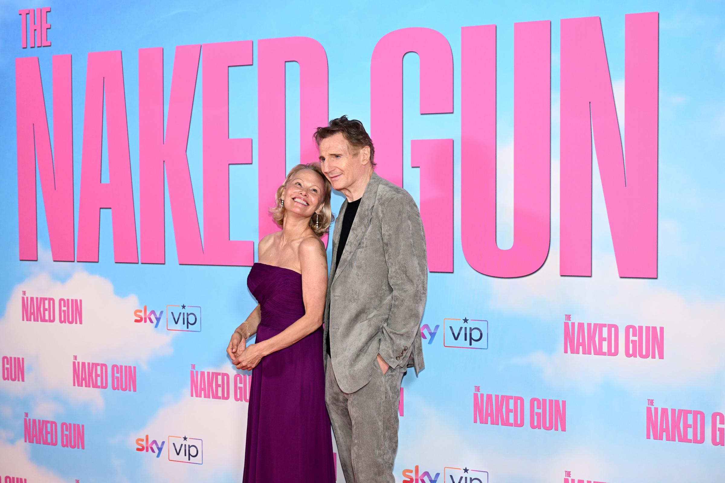 Pamela Anderson smiles at Liam Neeson as he also smiles for the camera at the "The Naked Gun" UK Premiere at Cineworld Leicester Square, in London, England on July 22, 2025 | Source: Getty Images