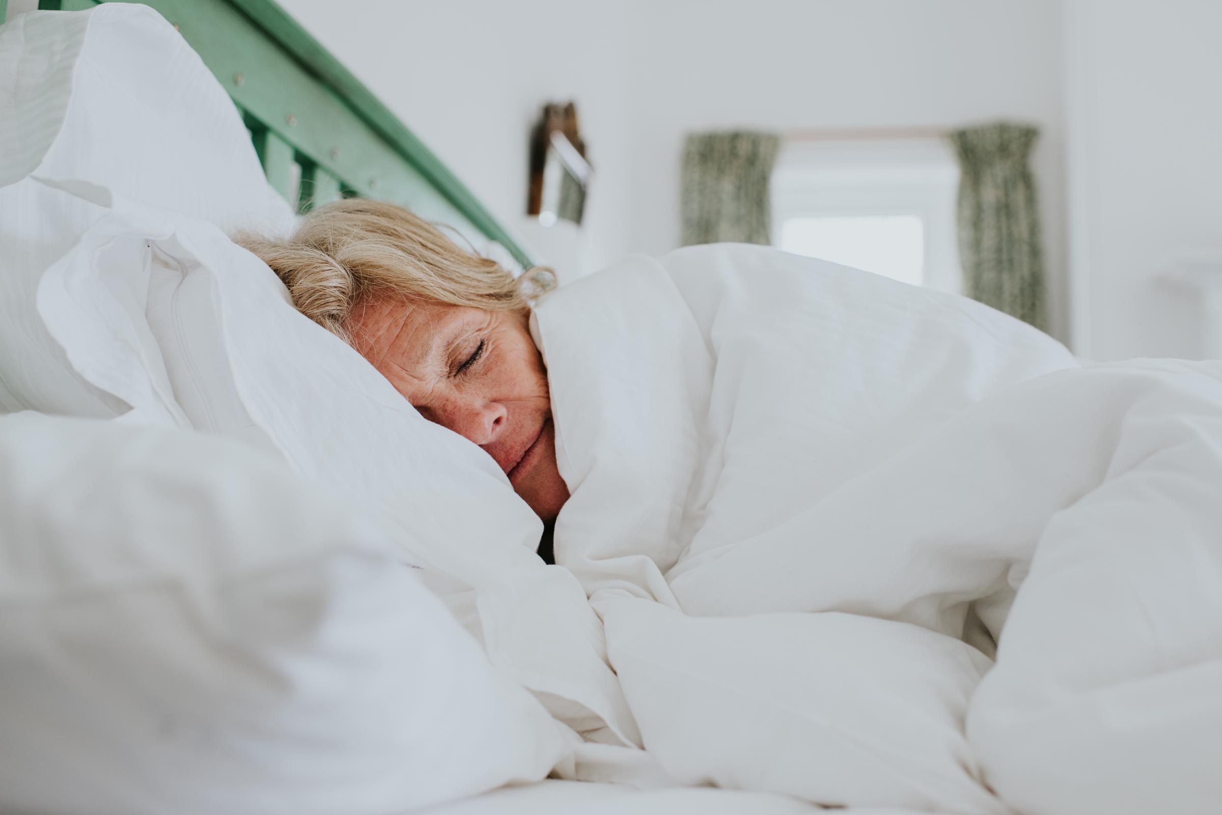A woman sleeping comfortably in her bed | Source: Getty Images
