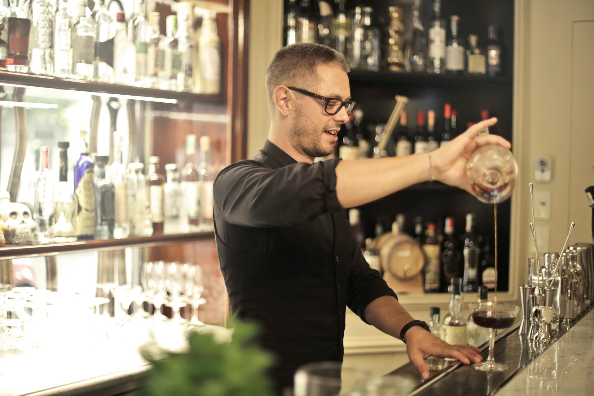 A bartender pouring wine into a glass | Source: Pexels