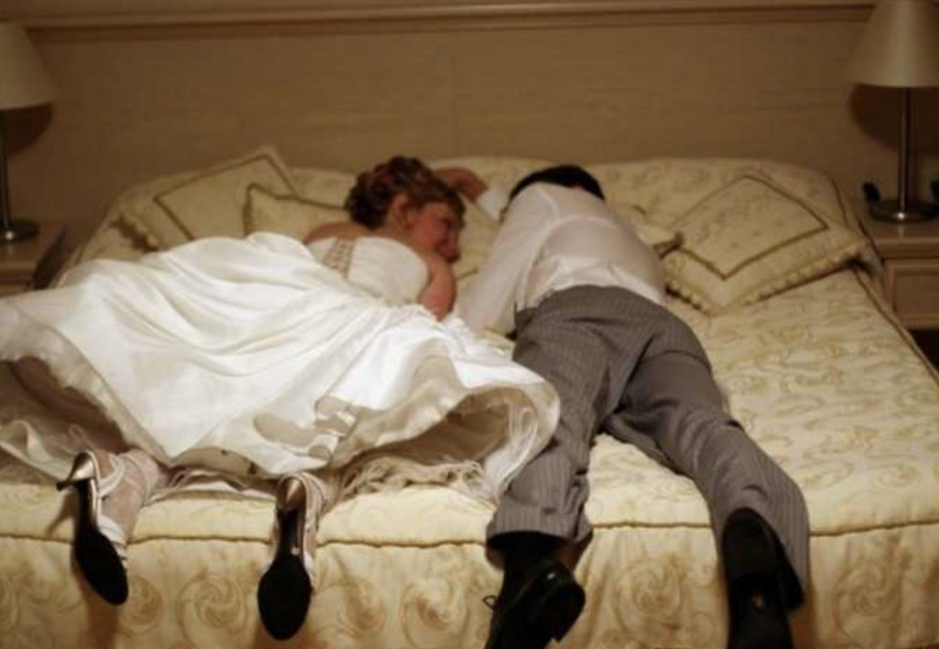 Newly-wed couple lying on a bed | Source: Shutterstock