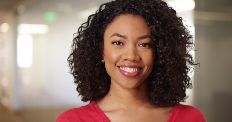 Photo of a woman with curly hair, smiling happily | Photo: Shutterstock.com