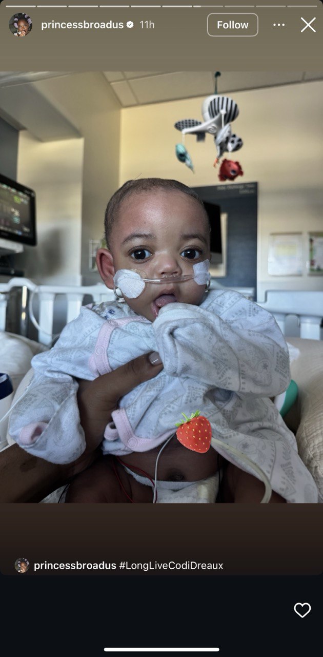 Codi Dreaux sits in a crib while a hand holds her, from a post dated February 9, 2026. | Source: Instagram Story/princessbroadus