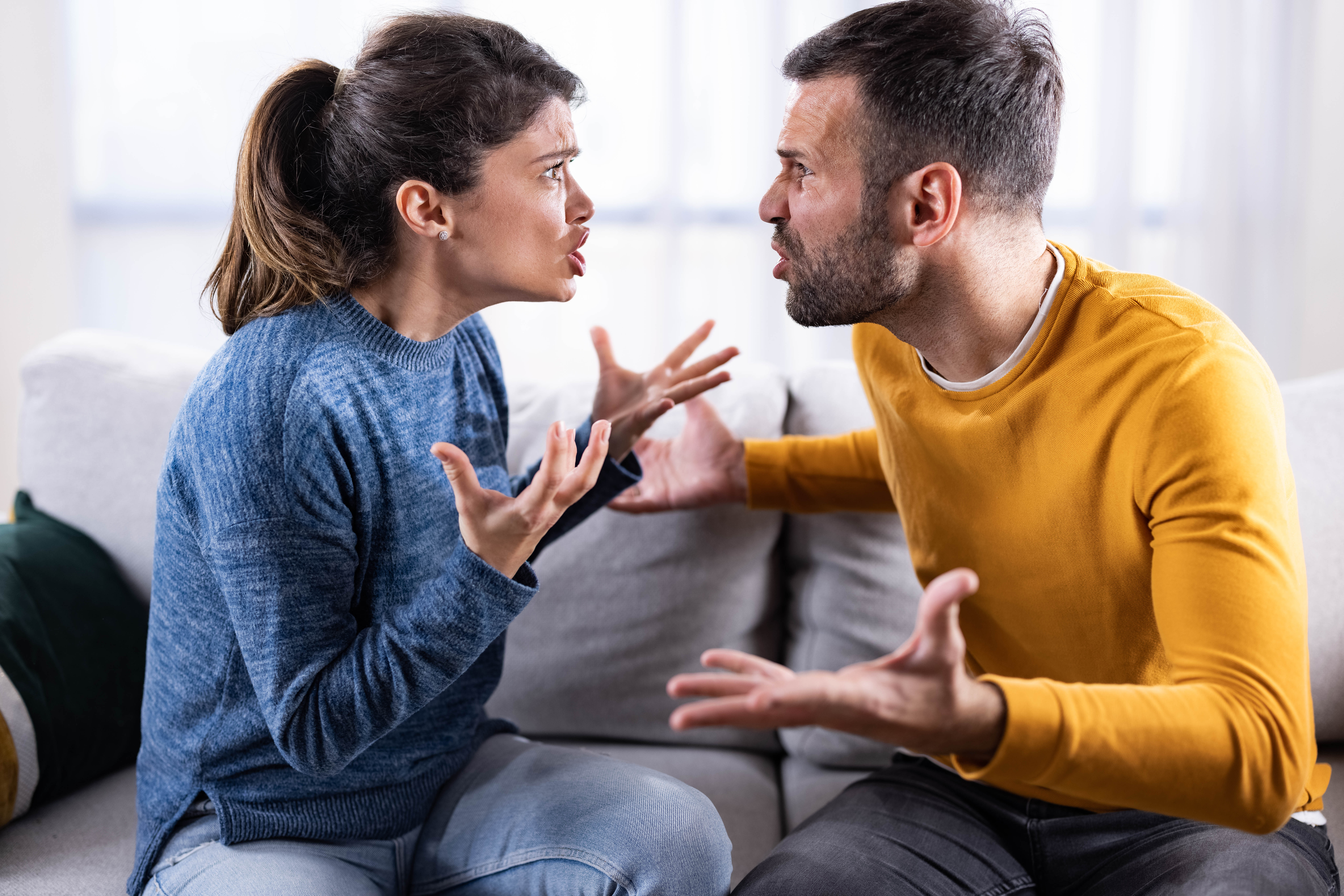 Mid adult couple arguing on sofa at home | Source: Getty Images