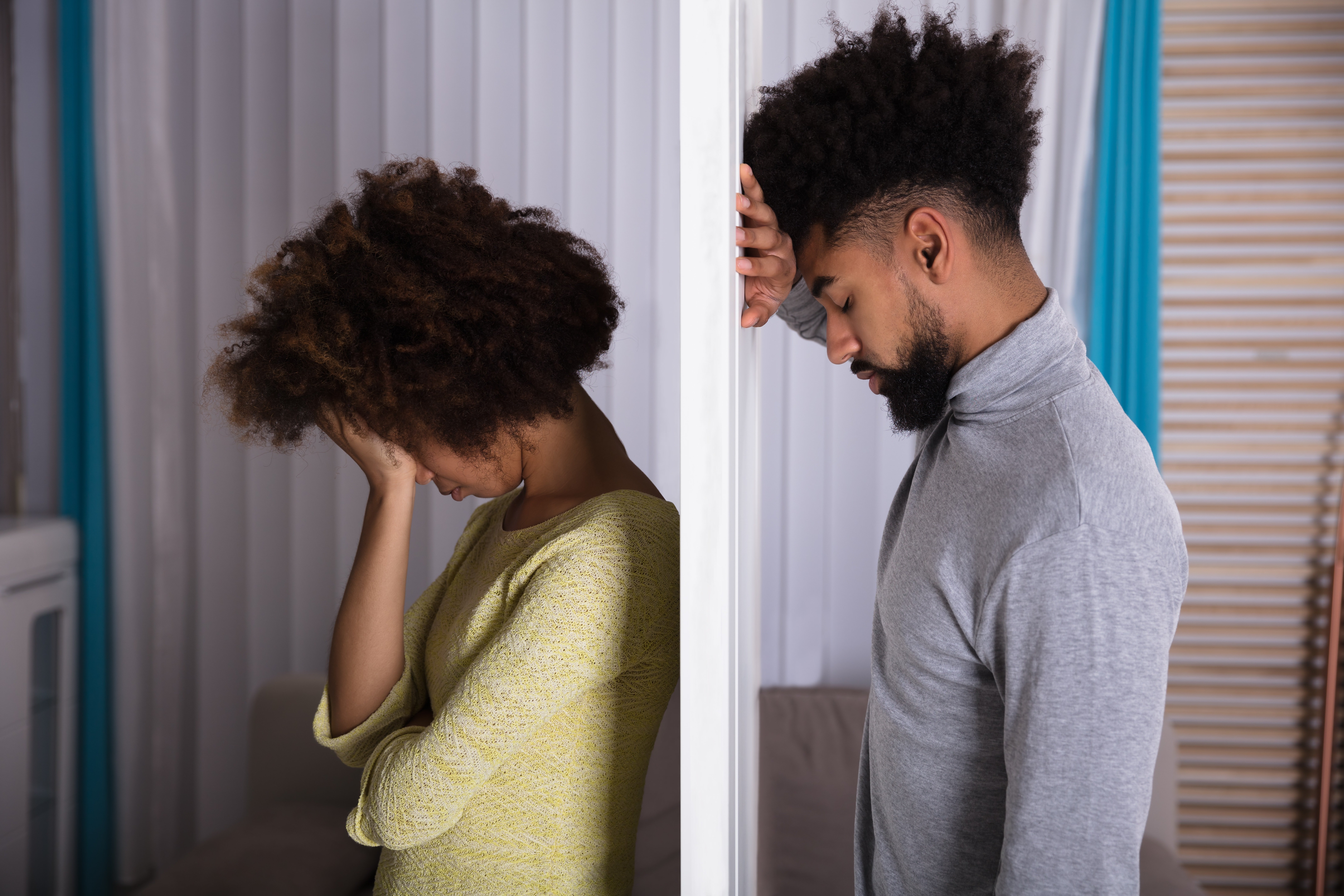 Young Unhappy Couple Standing Back To Back At Home | Photo: Shutterstock