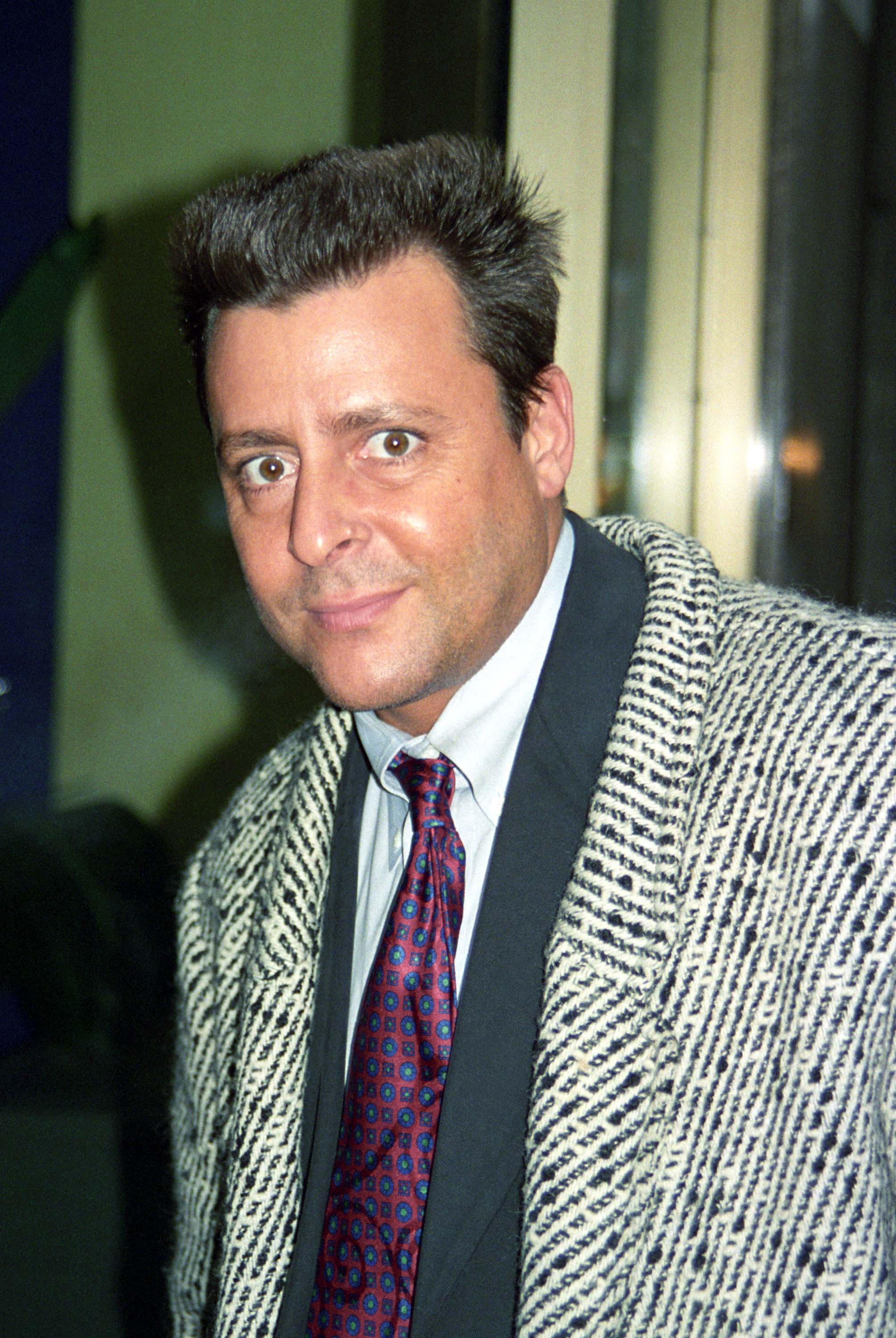 Sporting a patterned tweed coat, a red patterned tie, and a styled haircut, the actor made an appearance on "Fox After Breakfast" in New York City on February 11, 1997. | Source: Getty Images