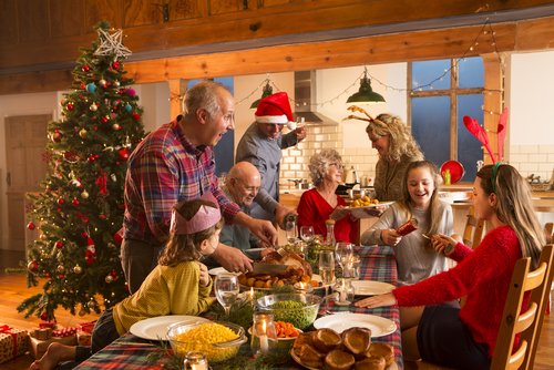 Familie am Weihnachtstisch beim Essen | Quelle: Shutterstock