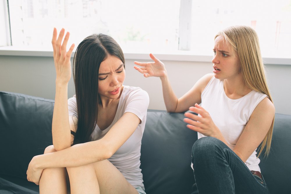 Two women arguing while sitting together on a couch | Photo: Shutterstock/By Estrada Anton