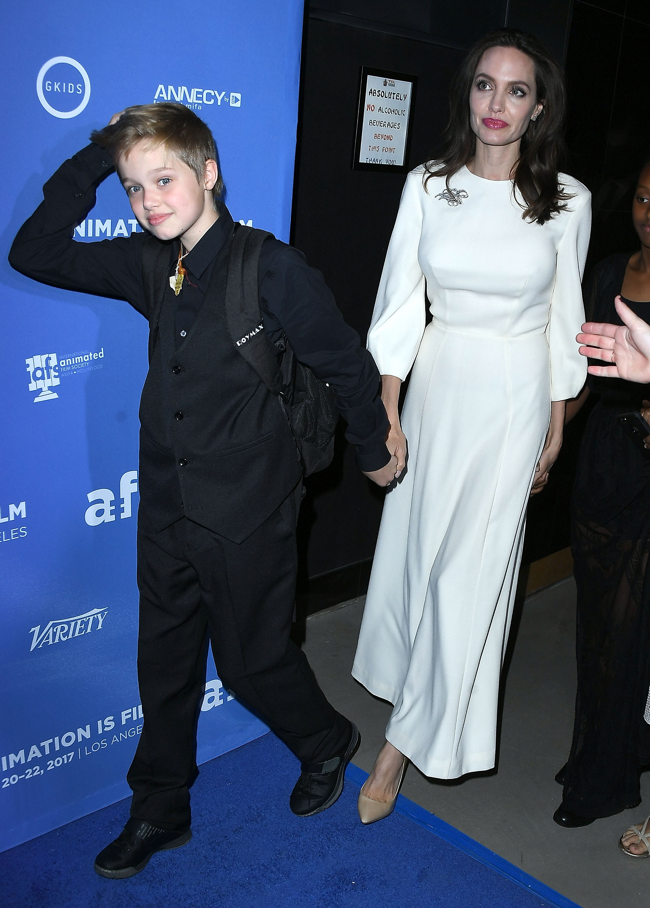 Shiloh Jolie-Pitt arrives at The Breadwinner premiere in a tailored black suit, holding hands with Angelina Jolie. With a vest and button-down, her look feels sharp, confident, and distinctly her own. The red carpet moment reinforces her signature style during this phase.