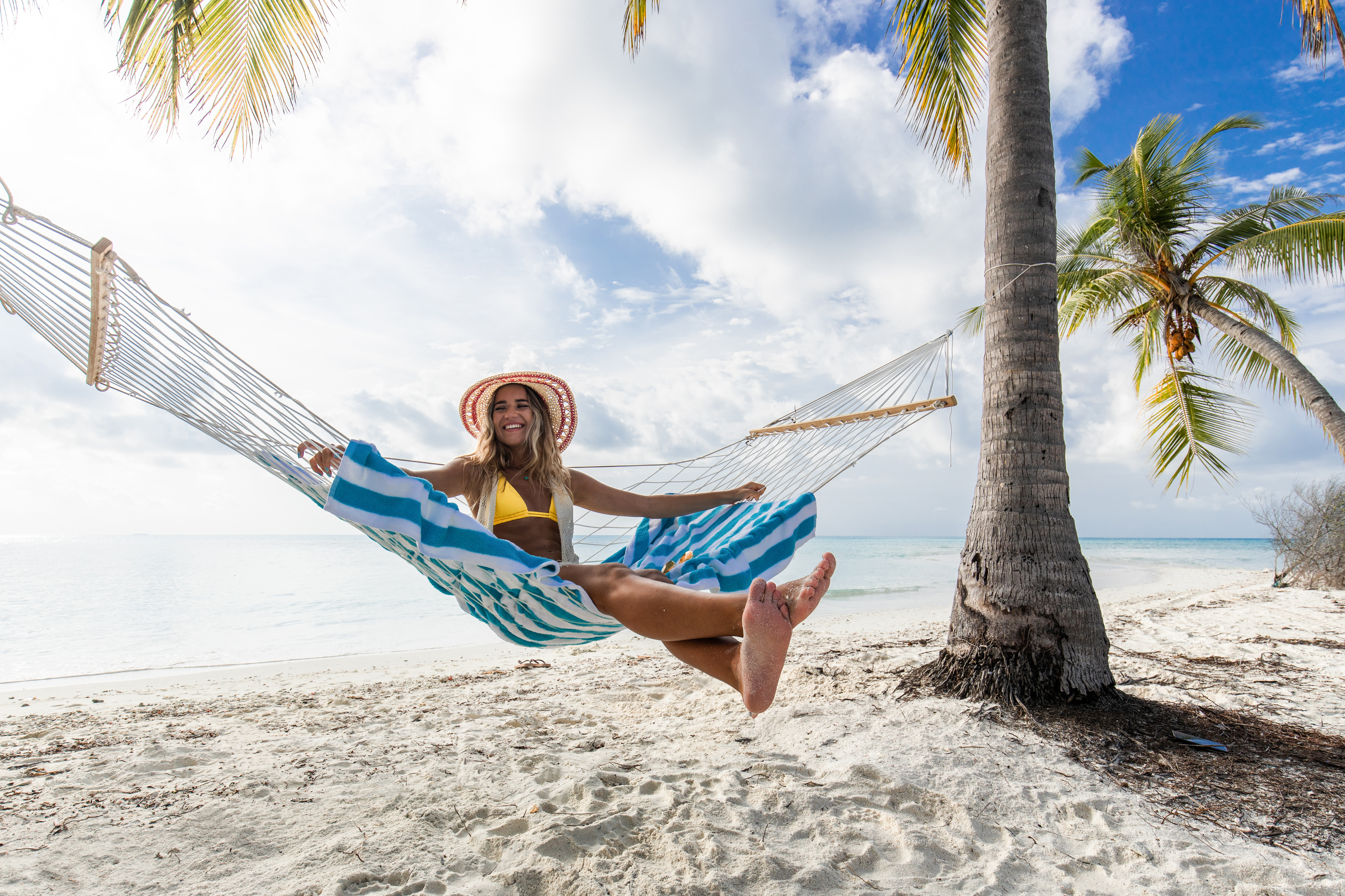 Young happy woman enjoying in hammock on the beach | Source: Getty Images