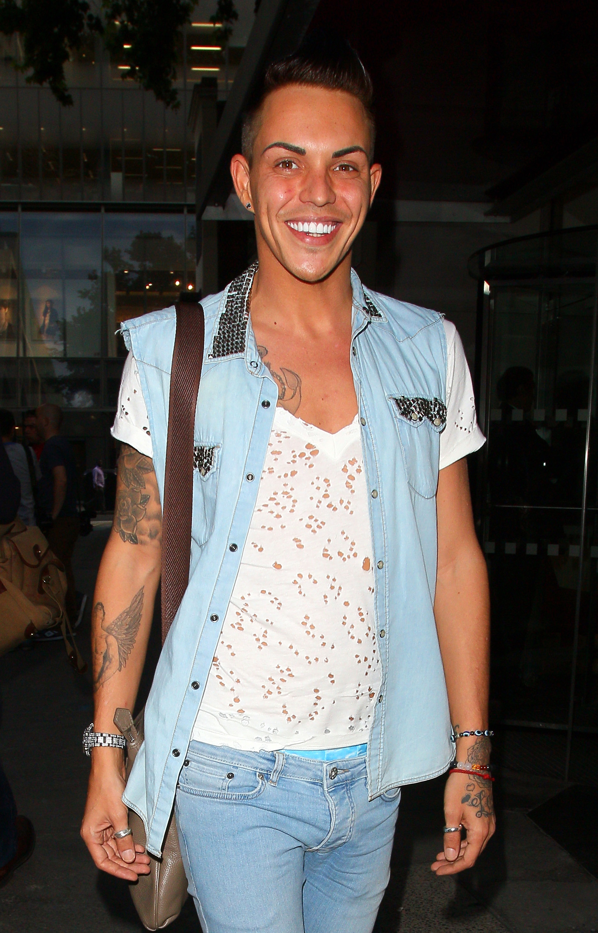 All smiles at the Rock Your Jeans party in London in September 2013, Norris arrived in a studded denim shirt layered over a distressed white tee, his arm tattoos — a mix of florals and a bird in flight — on full display.