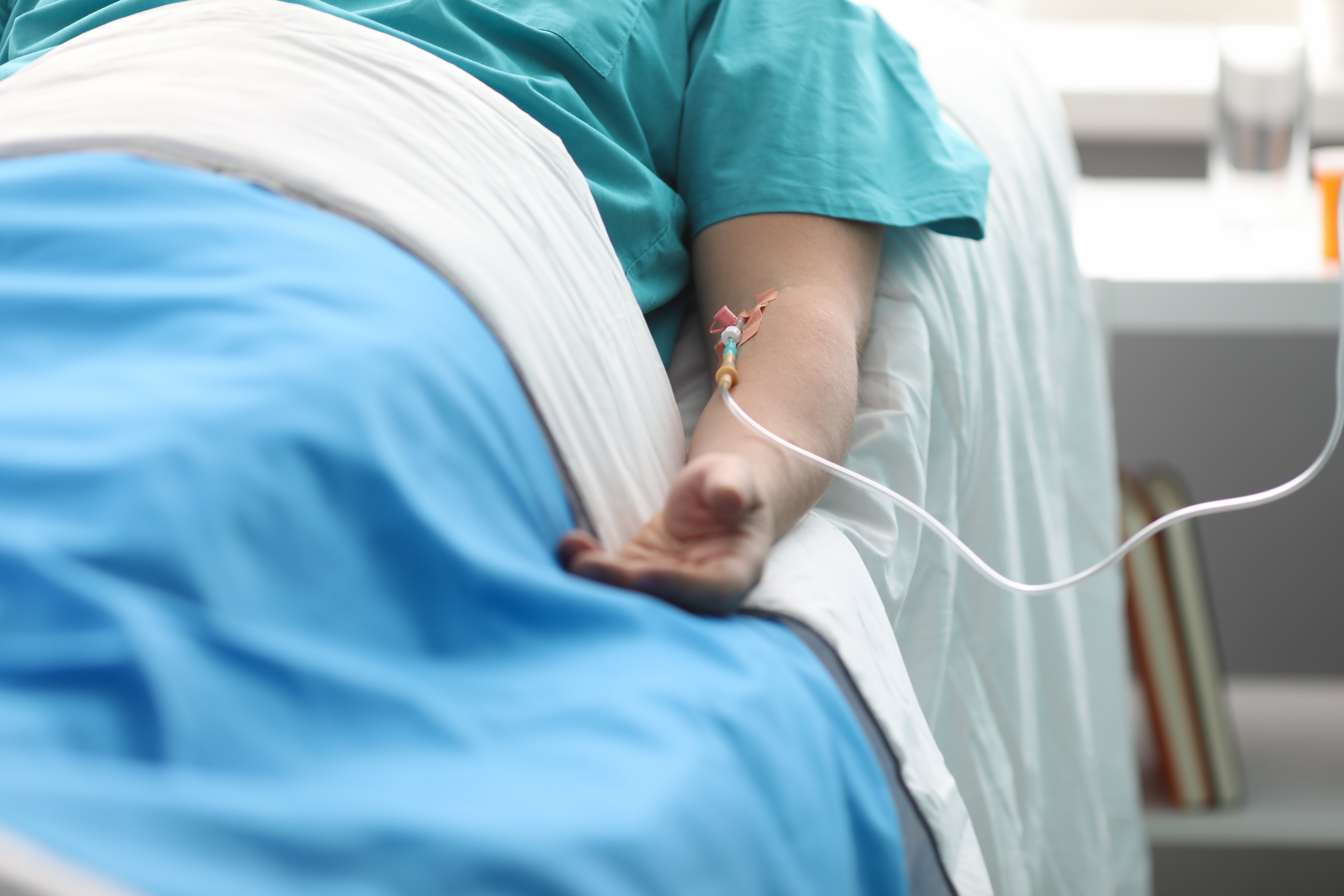 Main d'un jeune homme sur un lit à l'hôpital. | Photo : Shutterstock