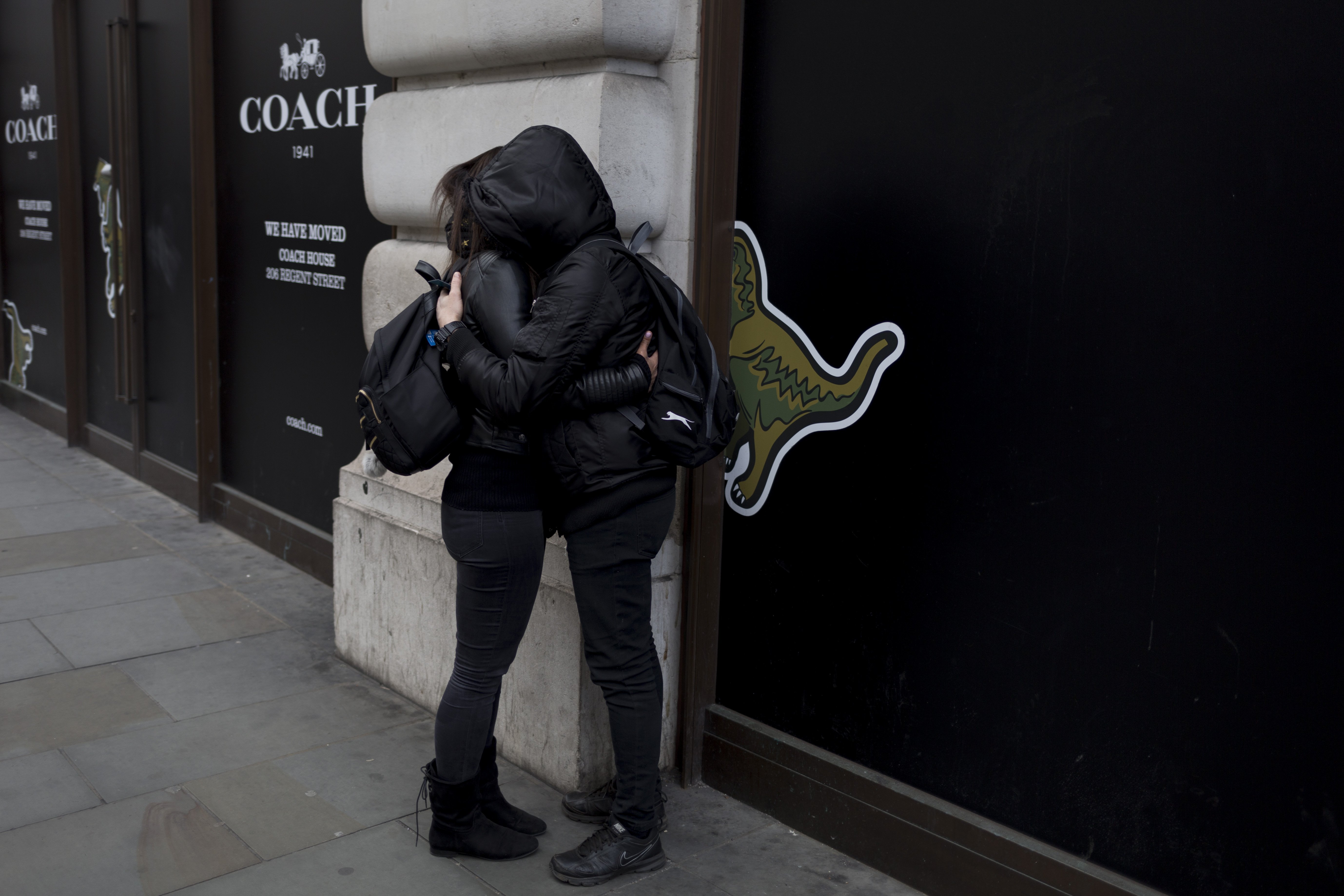 A couple wearing black hoodies with faces hidden, hug on Regent Street, on 21st March 2017|Photo: Getty Images