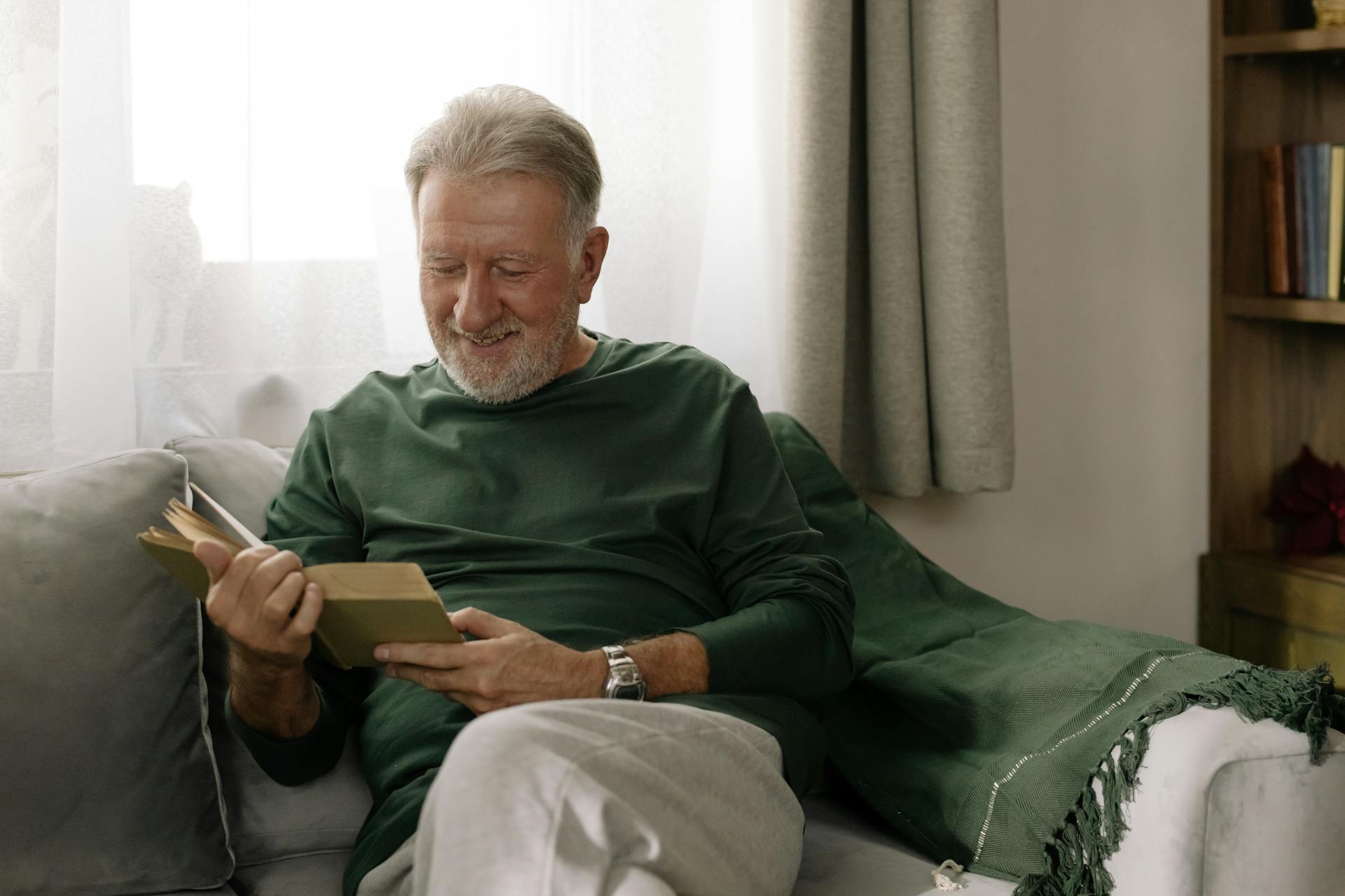 A smiling senior man reading a book | Source: Pexels