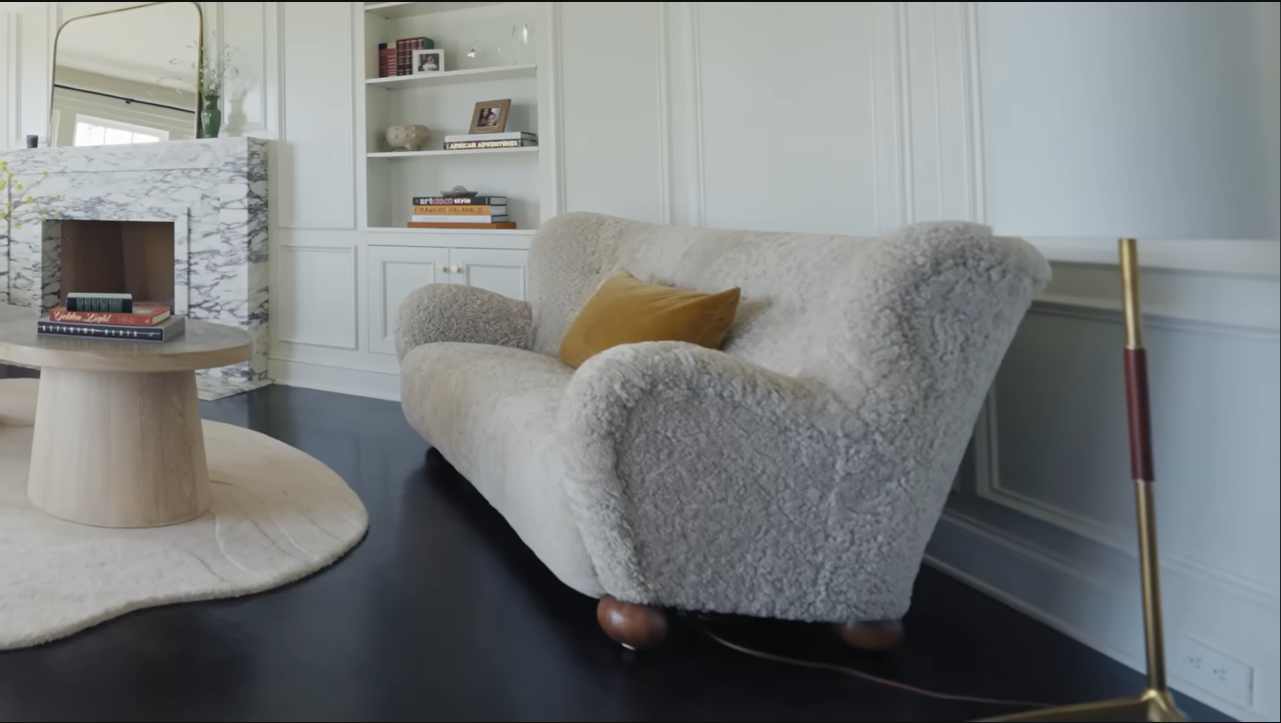 A secondary sitting area features a wonderfully plush, texturized sofa perfect for relaxing. | Source: YouTube/@Archdigest
