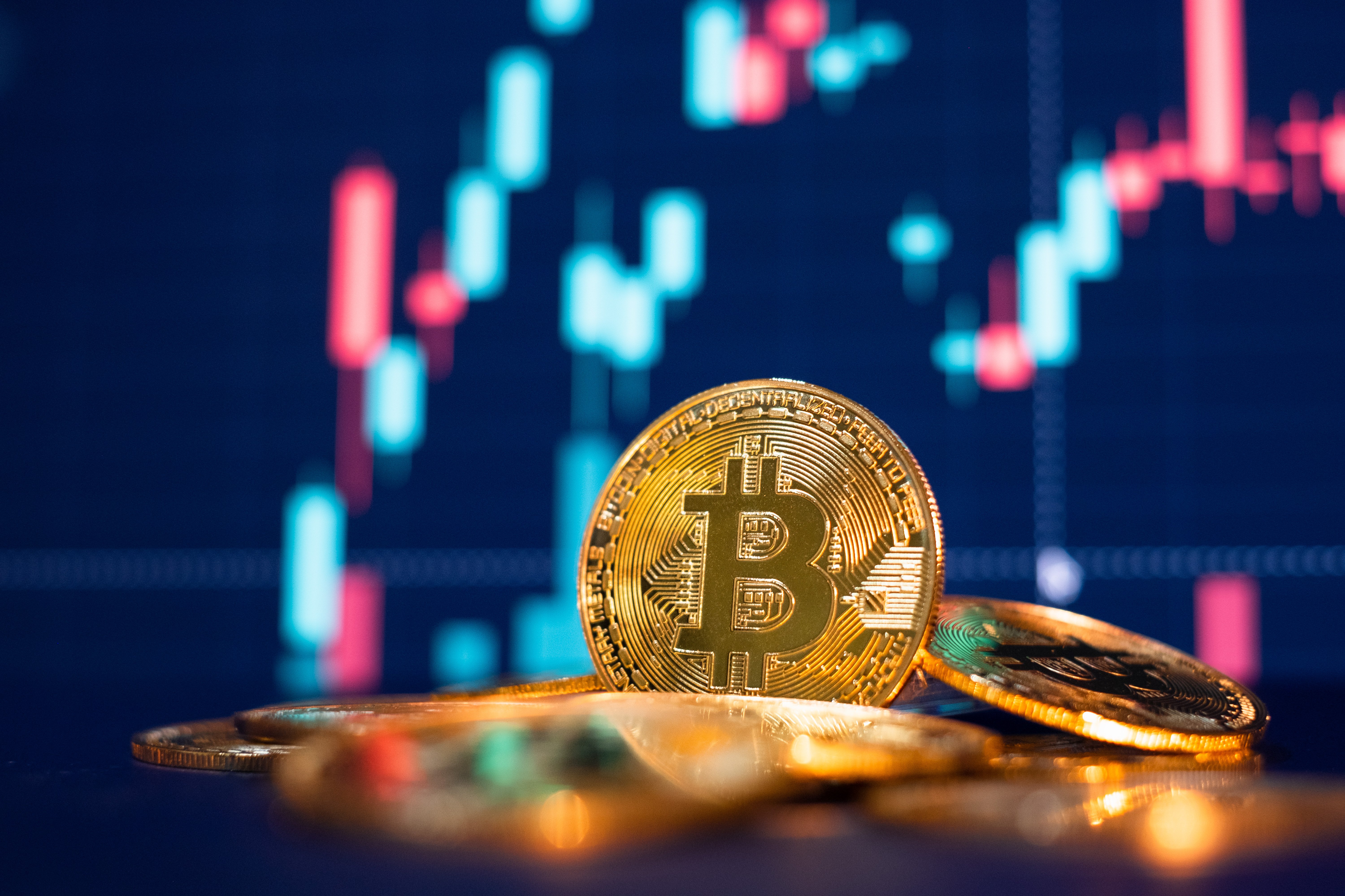 Close up on a Bitcoin with red and blue lights in the background. | Photo: Shutterstock 