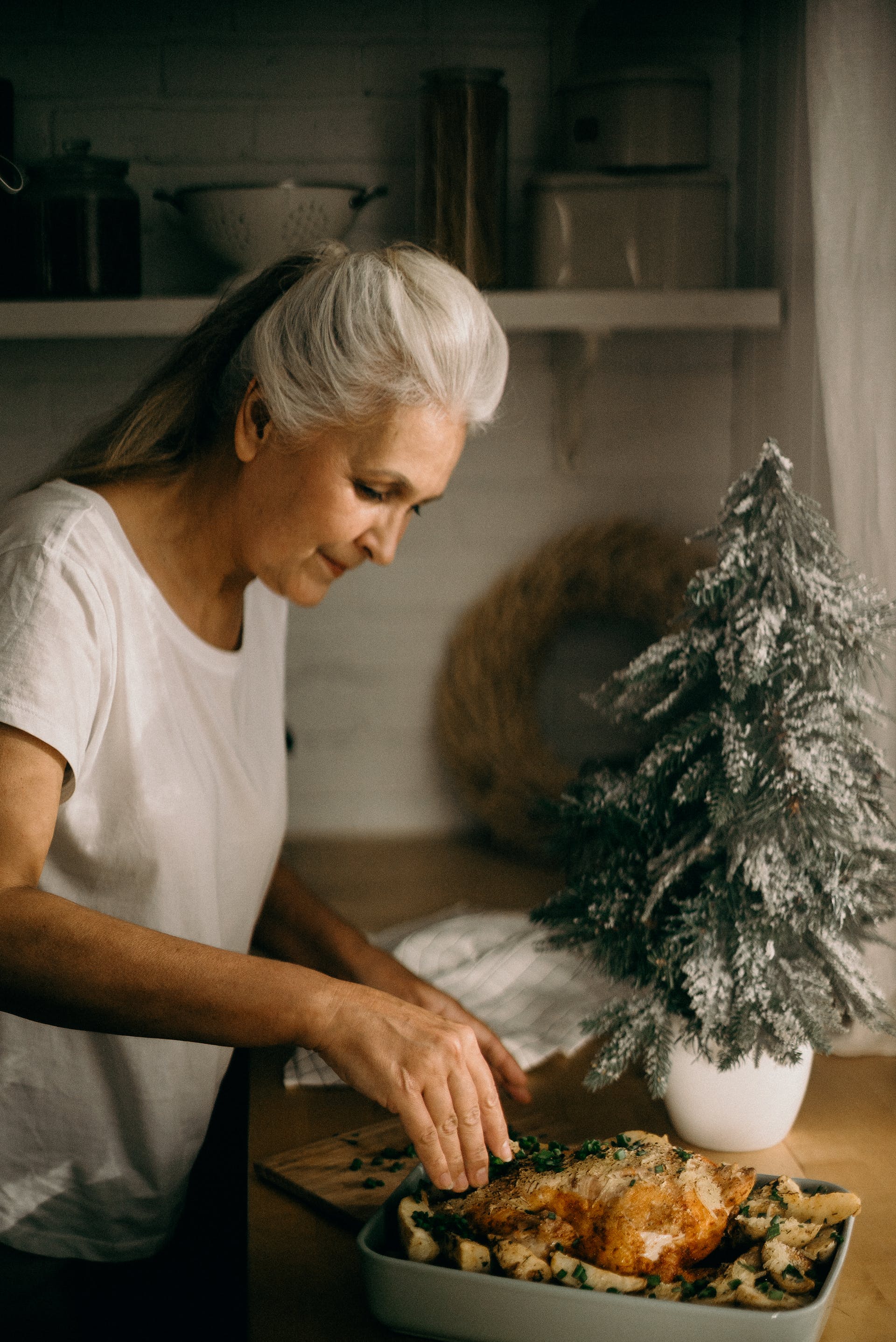 A senior woman standing in the kitchen in front of a dish | Source: Pexels