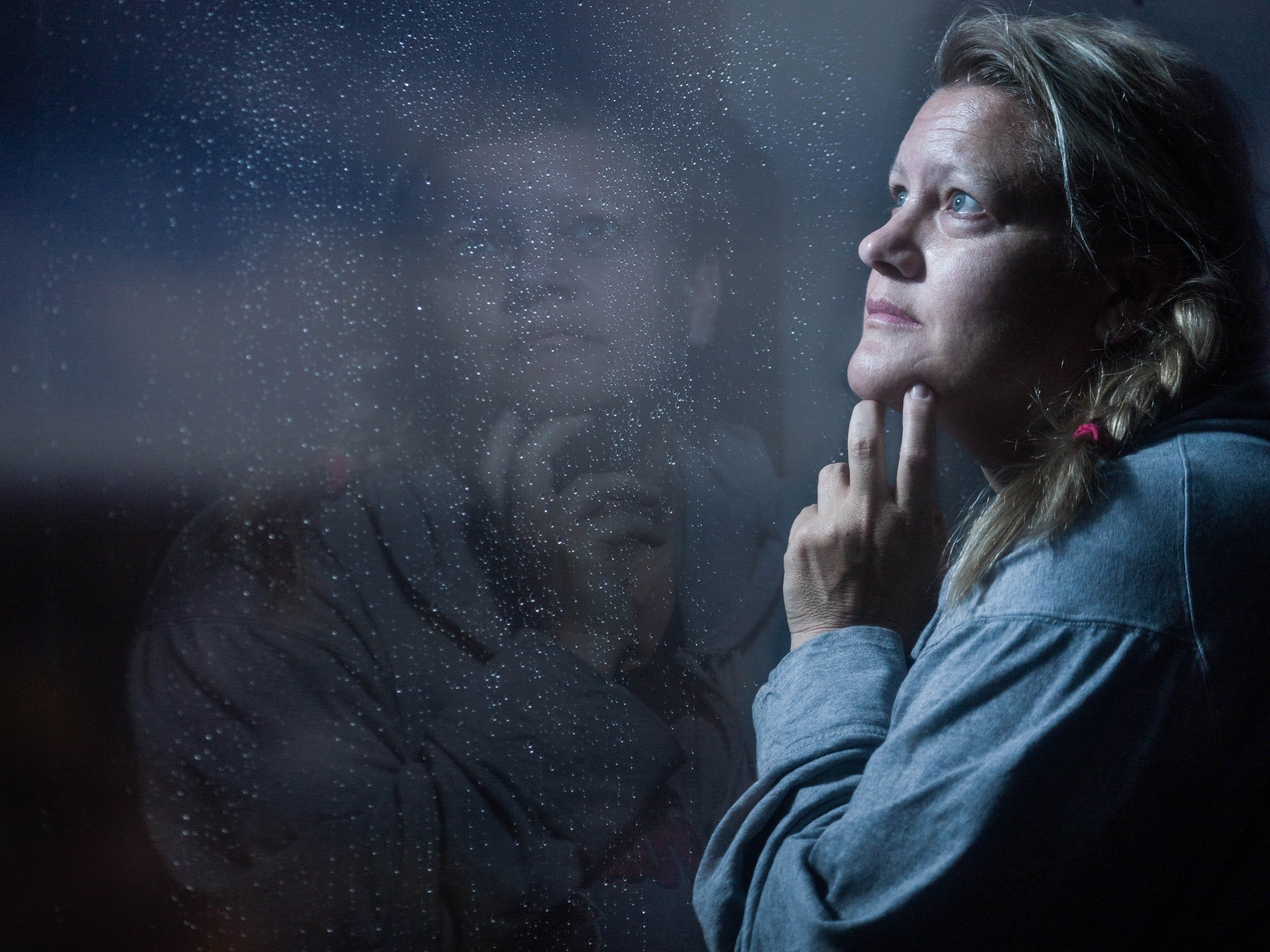 A woman looking outside a window. | Source: Unsplash