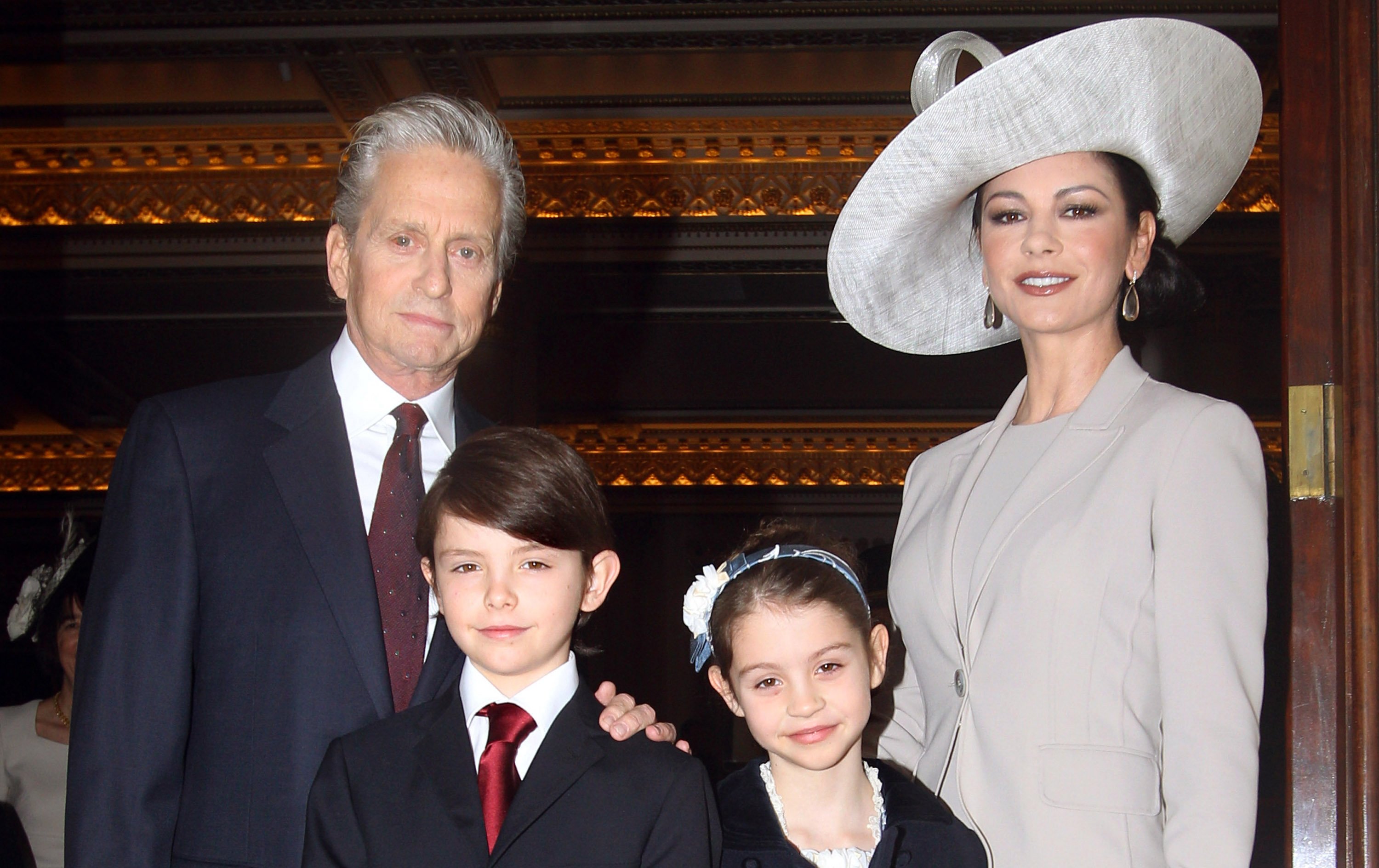 Catherine Zeta-Jones arrives with her husband, actor Michael Douglas and their children Dylan and Carys Douglas, to attend a Royal Investiture at Buckingham Palace on February 24, 2011 in London, England ┃Source: Getty Images