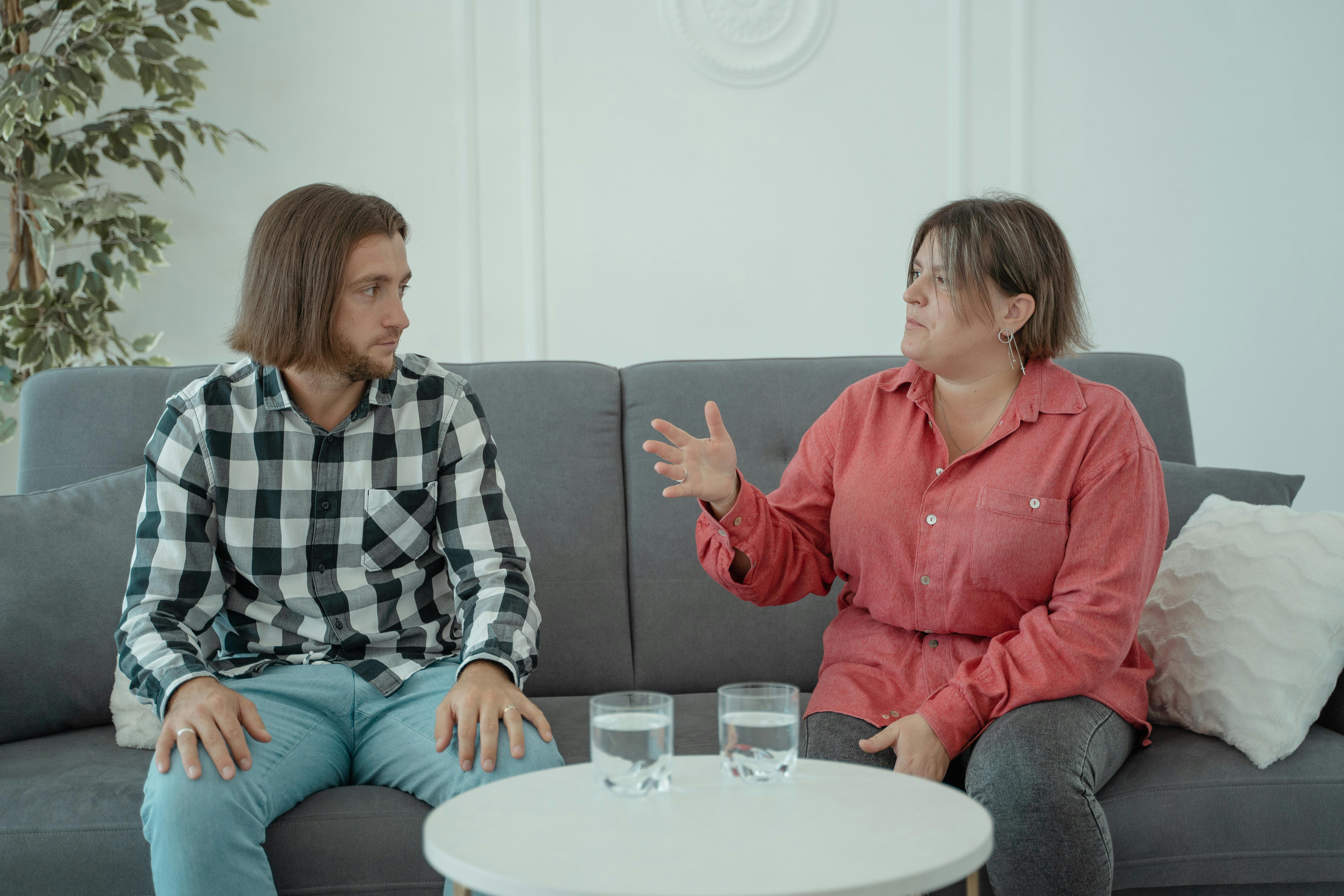 A man and woman having a serious discussion in a living room | Source: Pexels