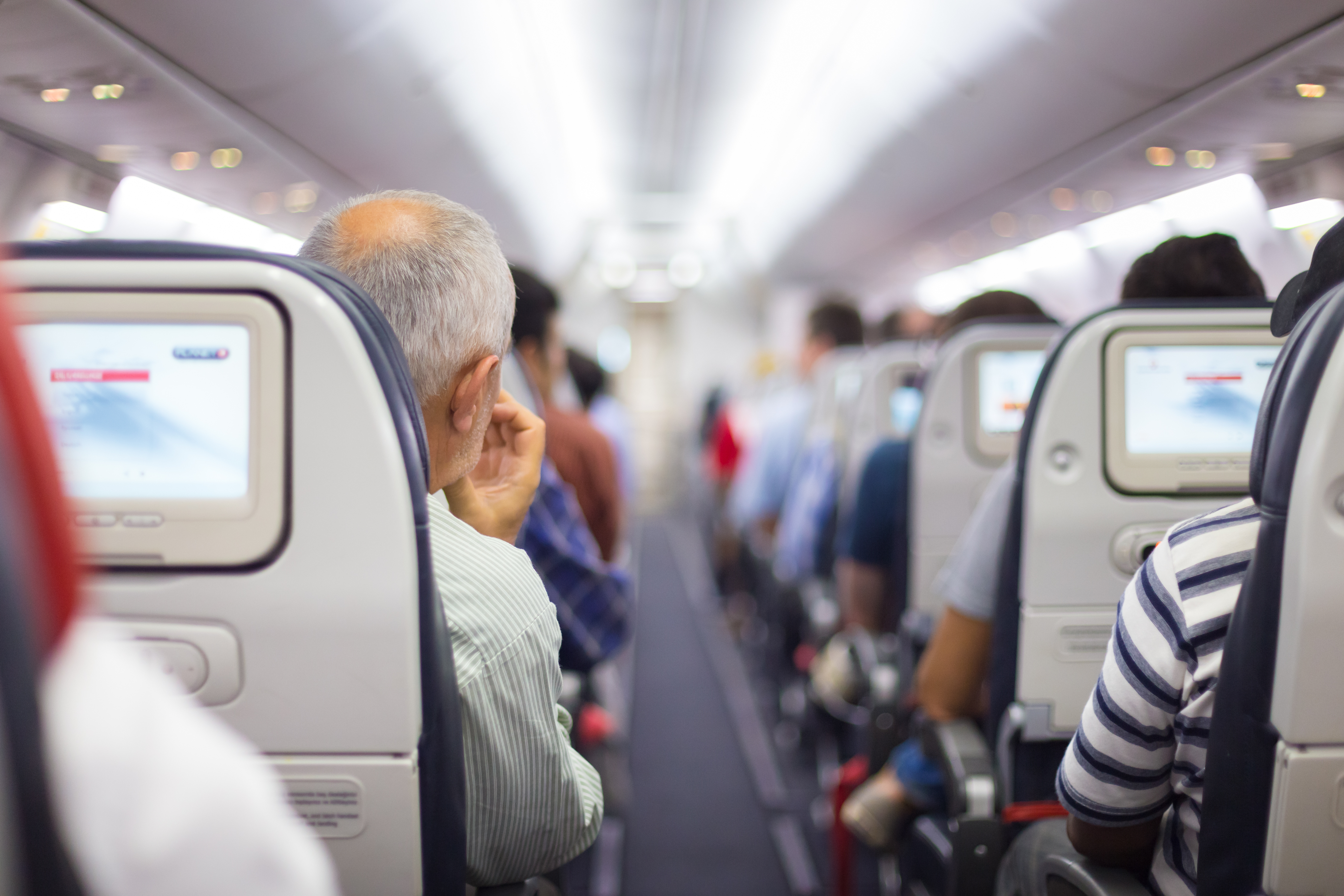 Interior of airplane with passengers on seats waiting to taik off. | Source: Shutterstock