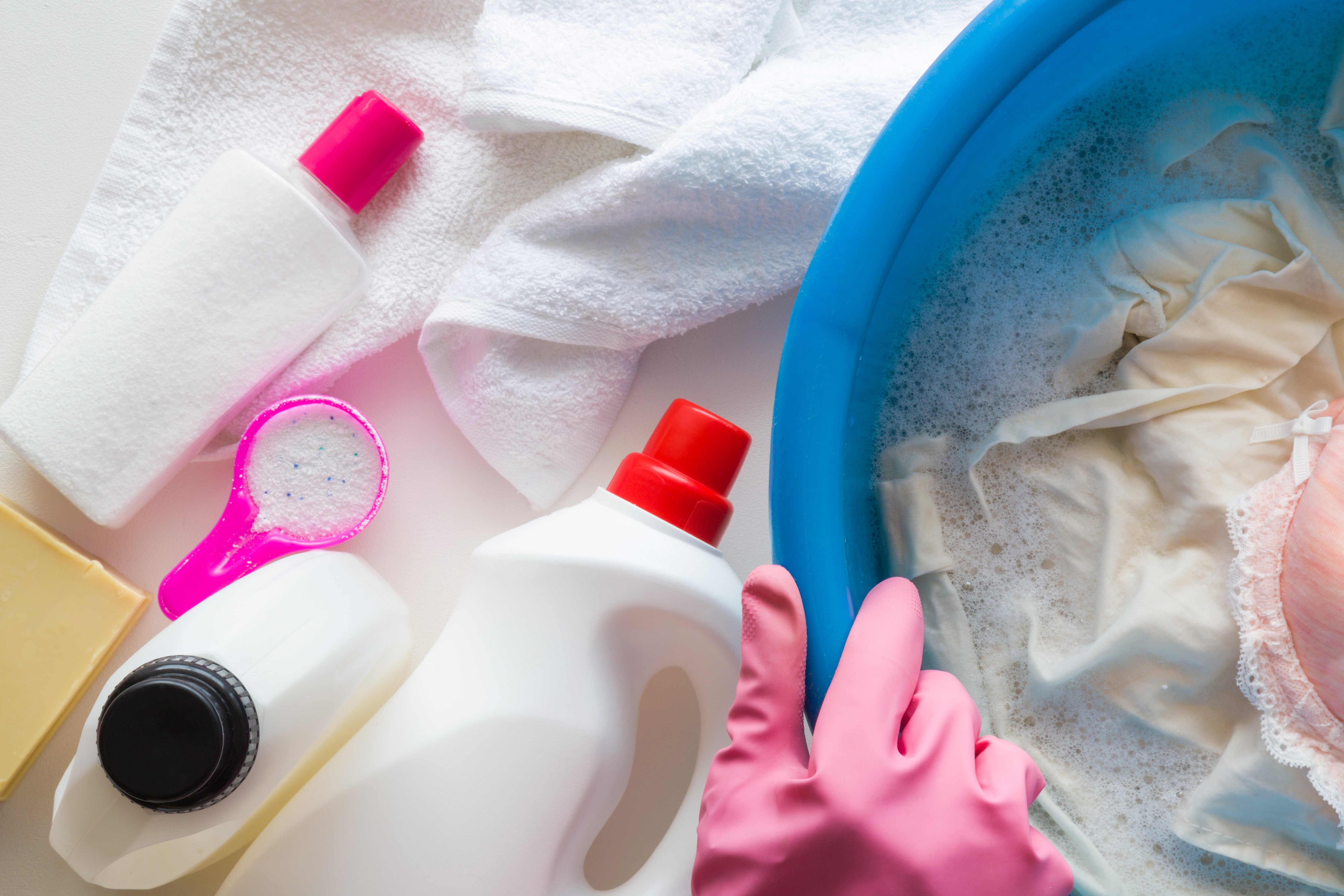 Man with rubber protective gloves washing and disinfecting clothes