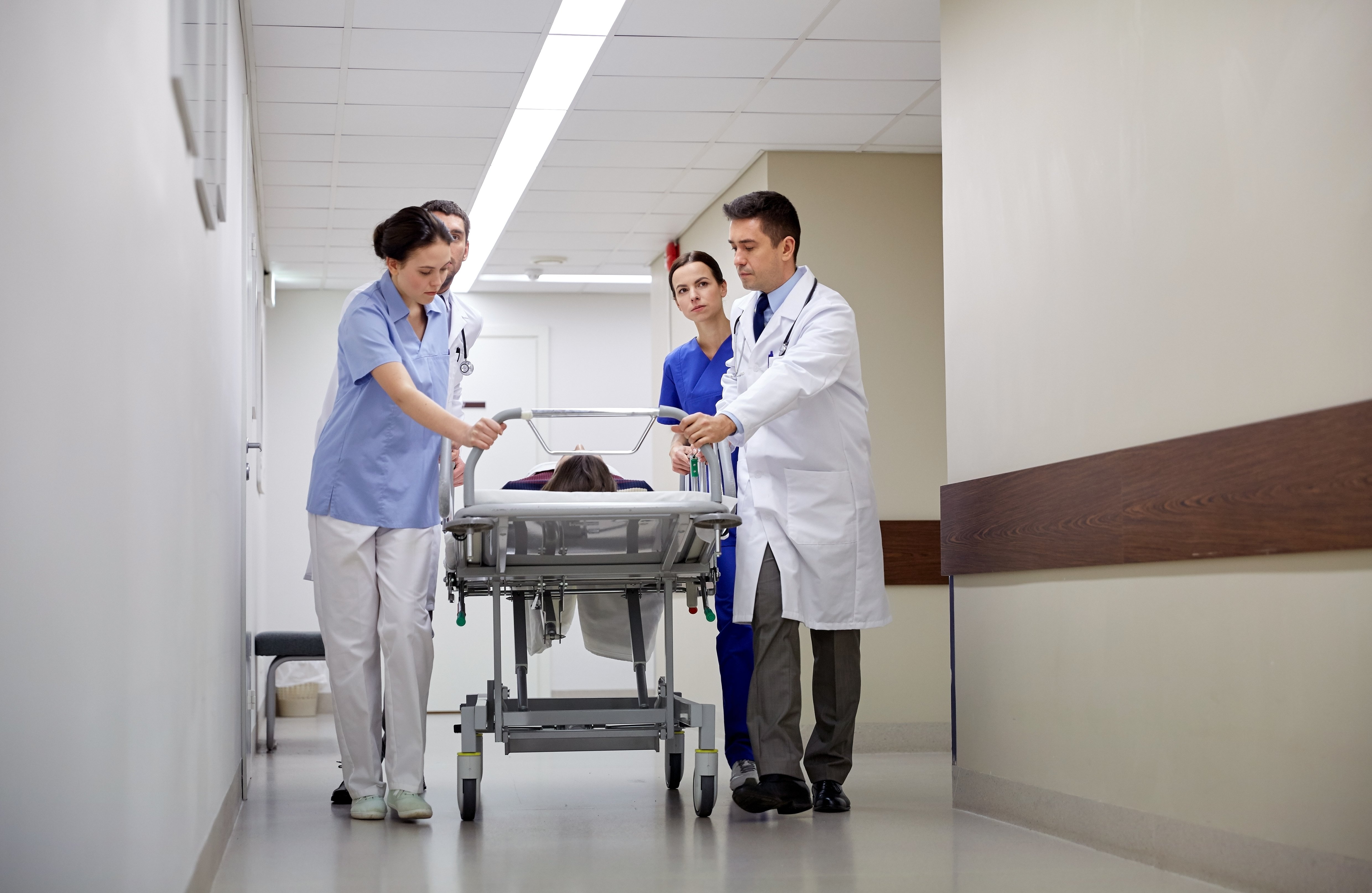 Mediziner und Patient im Notfall auf Krankenhausliege | Quelle: Shutterstock