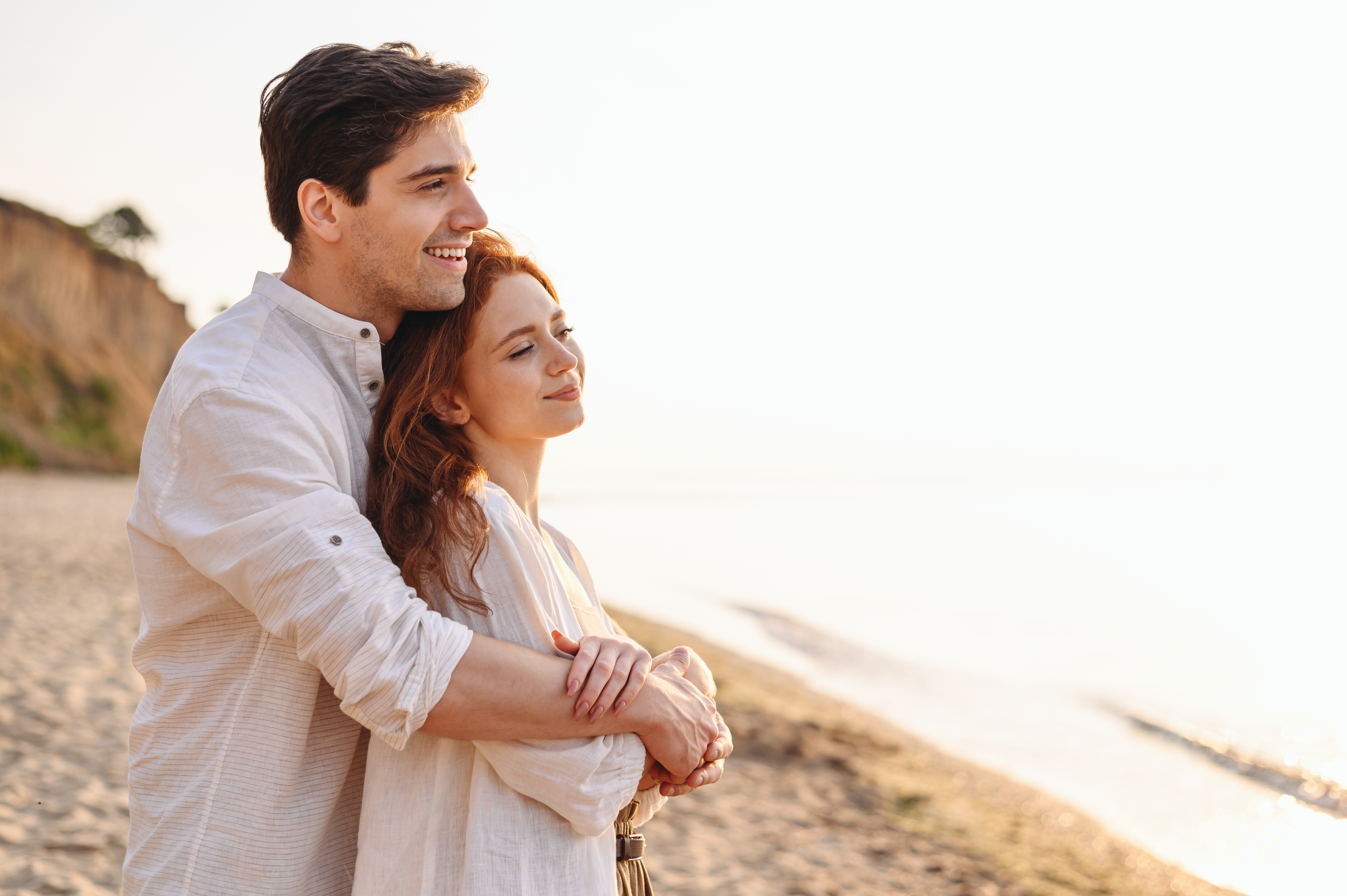 A happy couple standing on a beach | Source: Shutterstock