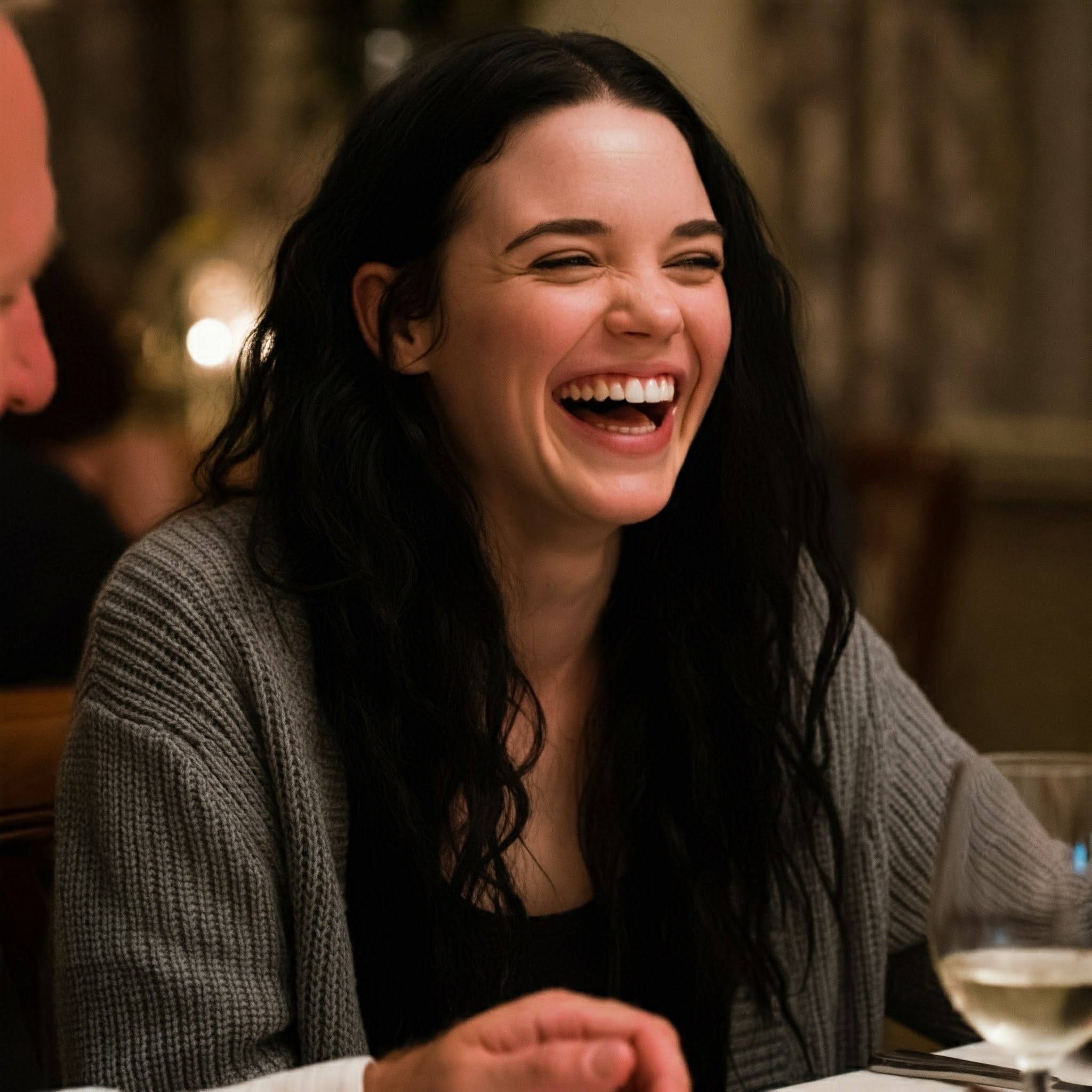 A woman laughing at dinner | Source: Gemini