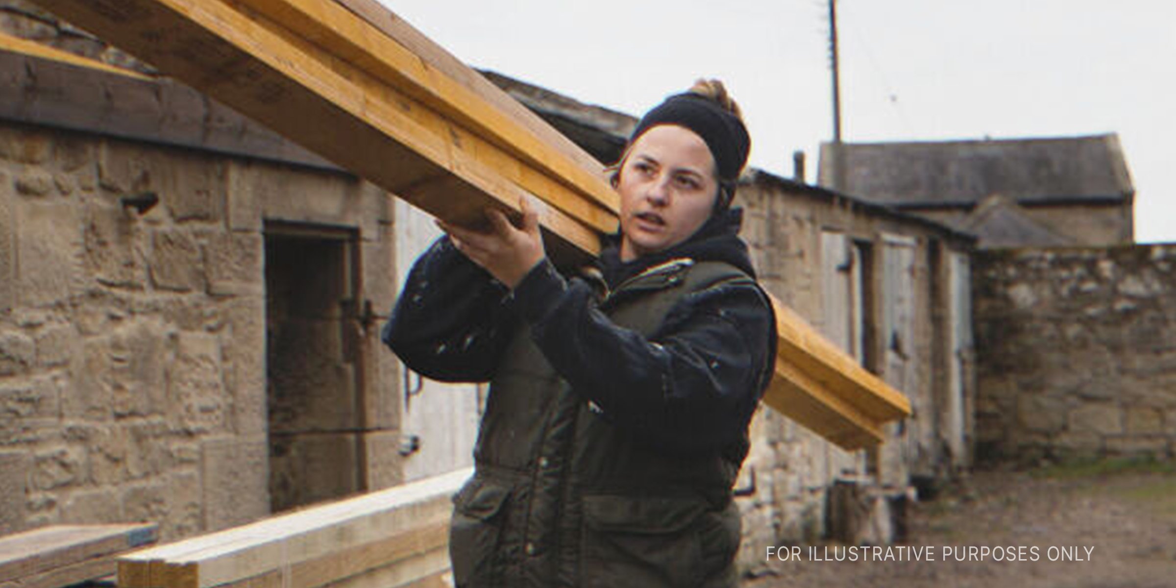 Woman carrying wooden slabs on shoulder | Source: Getty Images