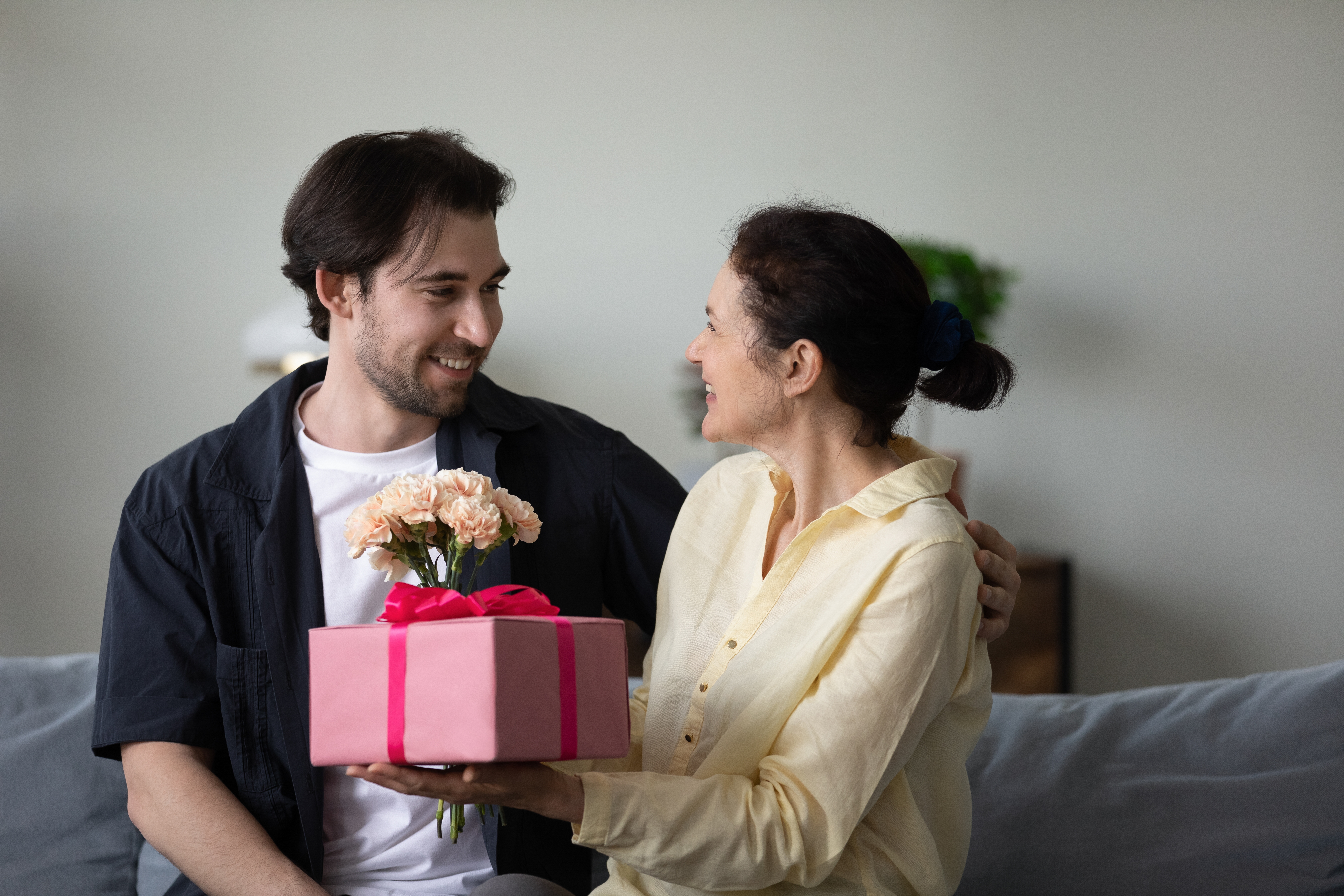 A woman receiving a gift from a young man | Source: Shutterstock