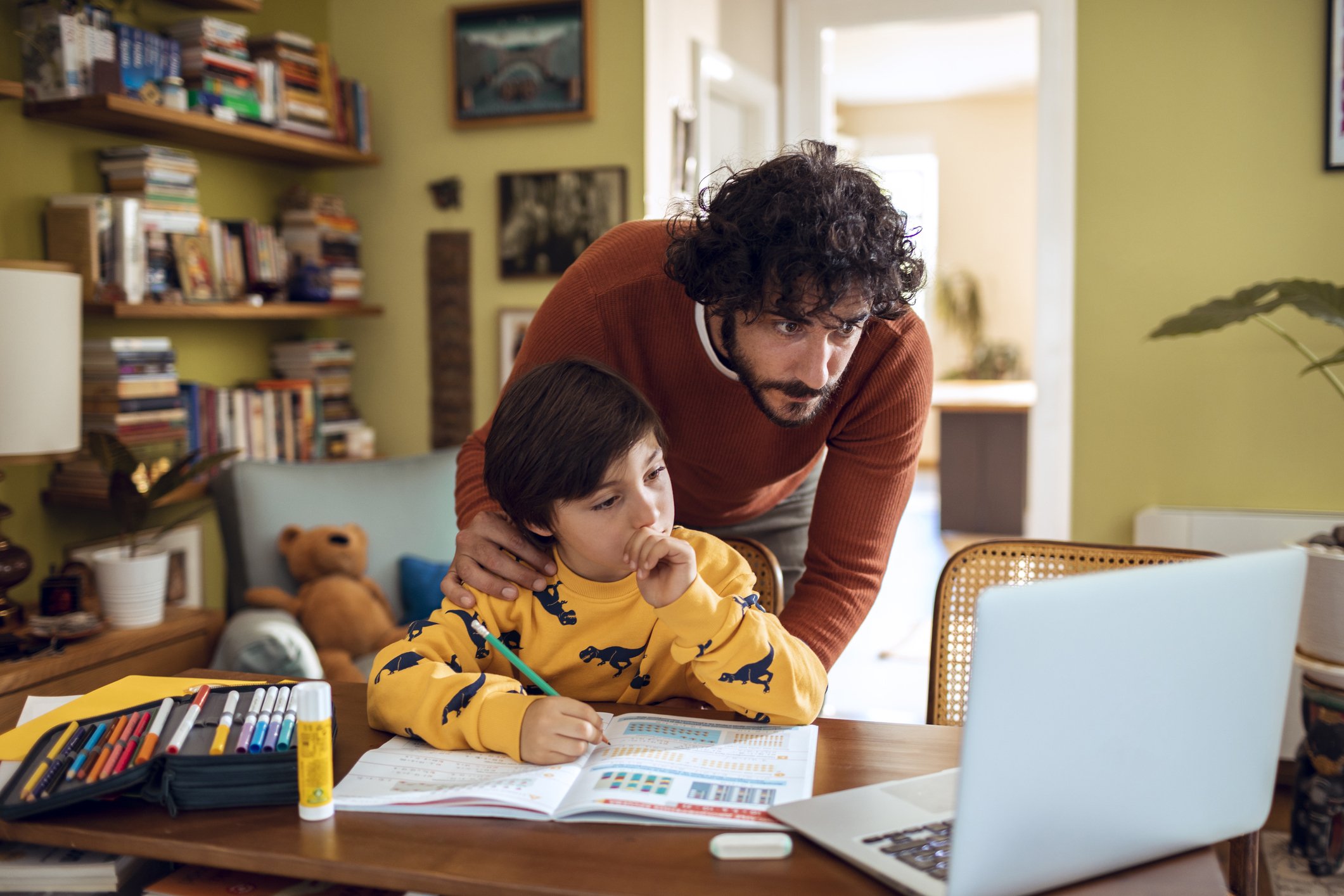 Un père aidant son fils à faire ses devoirs. | Photo : Getty Images