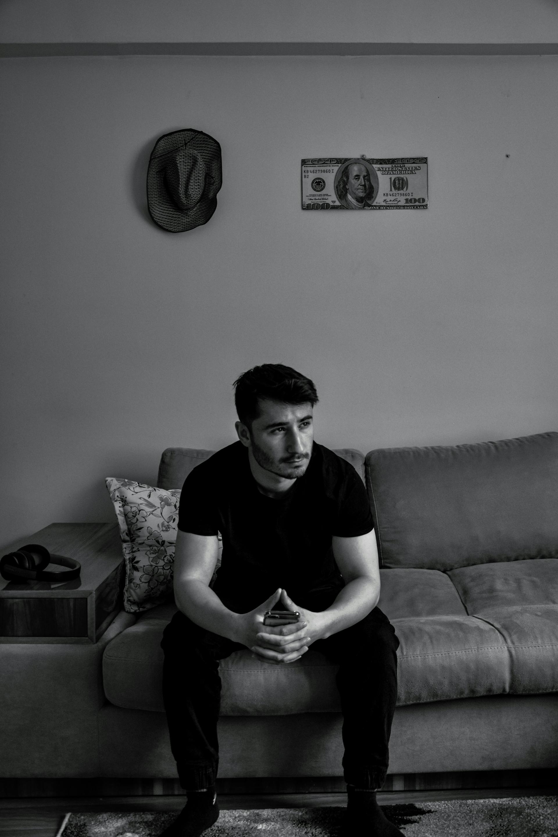 Grayscale photo of a man sitting on a sofa | Source: Pexels