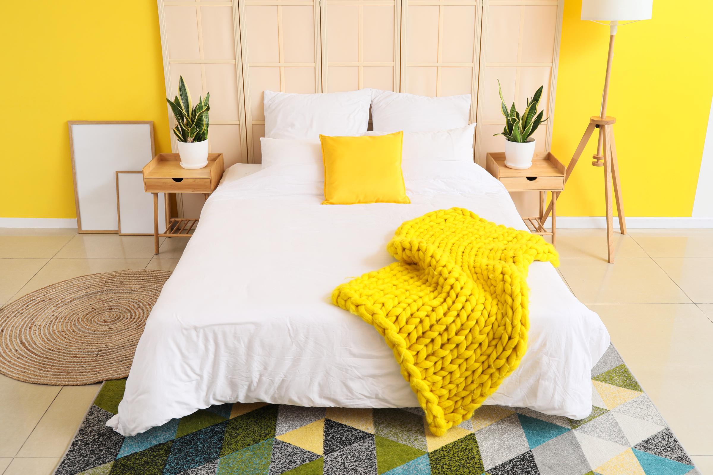A bedroom with bright yellow walls | Source: Shutterstock