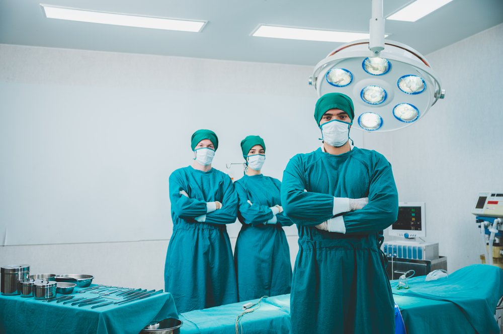 A photo of a doctor and his team prepped and ready for surgery | Photo: Shutterstock