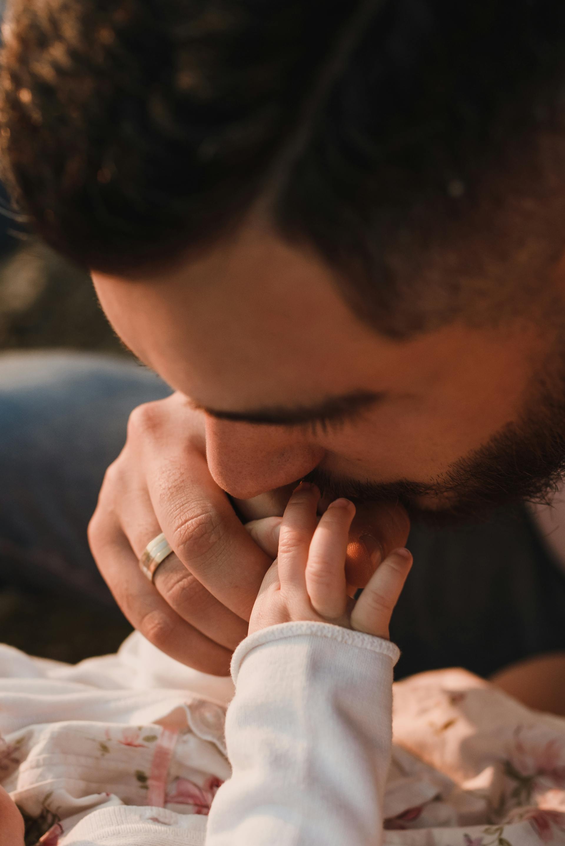 A man kissing a babys hand | Source: Pexels