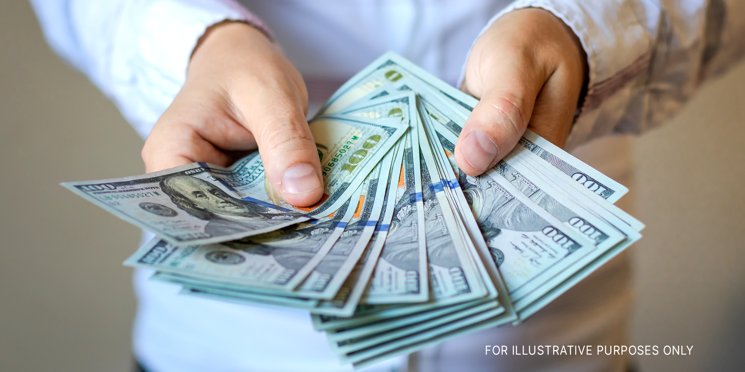 A person holding dollar bills | Source: Shutterstock