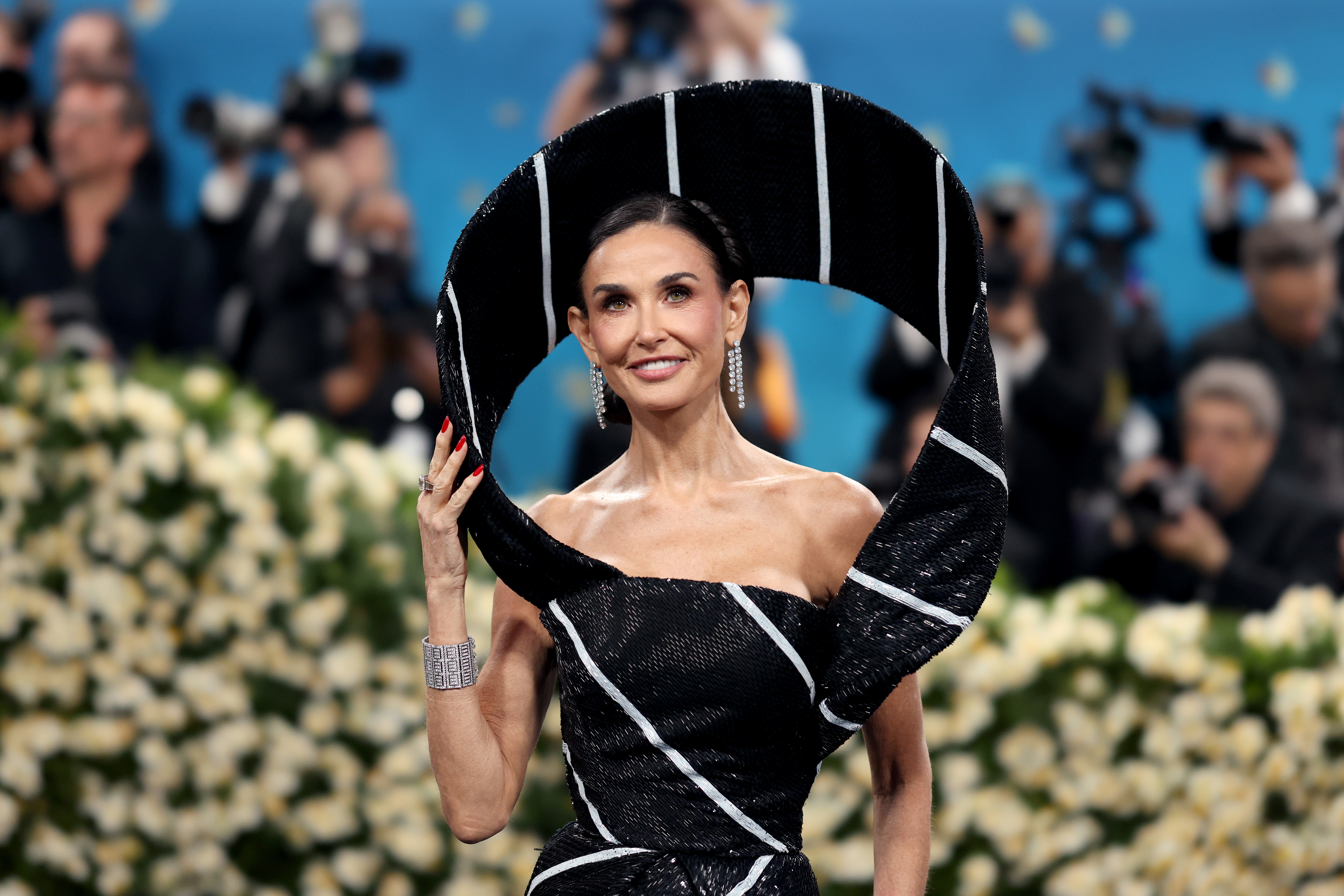 Demi Moore attends the 2025 Met Gala celebrating "Superfine: Tailoring Black Style" at the Metropolitan Museum of Art on May 5, 2025, in New York City. The actress wore her hair pulled back into a sleek updo, complementing her sculptural black-and-white gown with matching statement accessories.