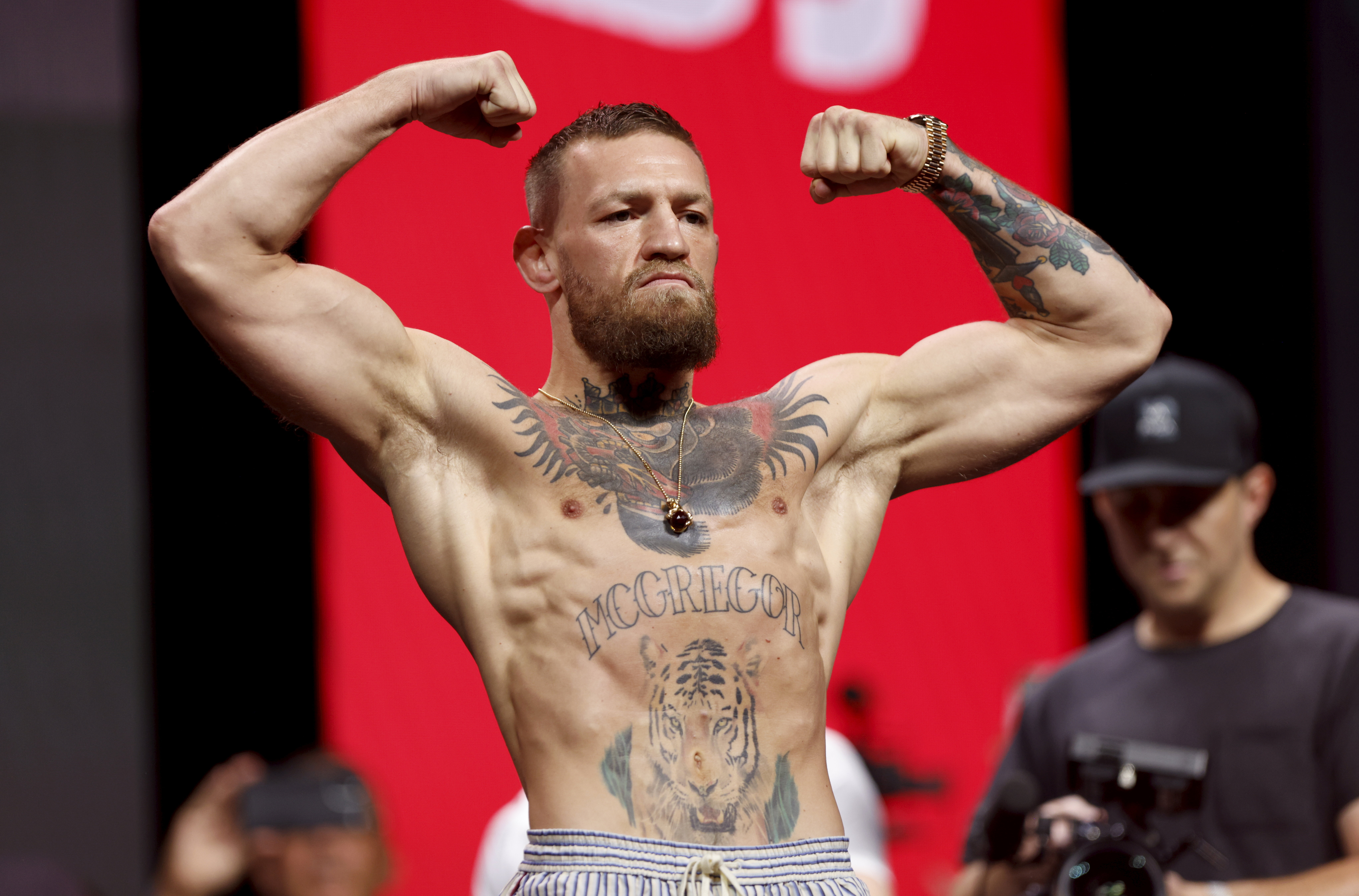 Conor McGregor flexes during the UFC 264 weigh-ins at T-Mobile Arena in Las Vegas on July 9, 2021. After years of competing in multiple weight classes, the Irish fighter appeared significantly more muscular than during his featherweight days, showcasing the larger frame that had become a defining feature of the later stages of his career.
